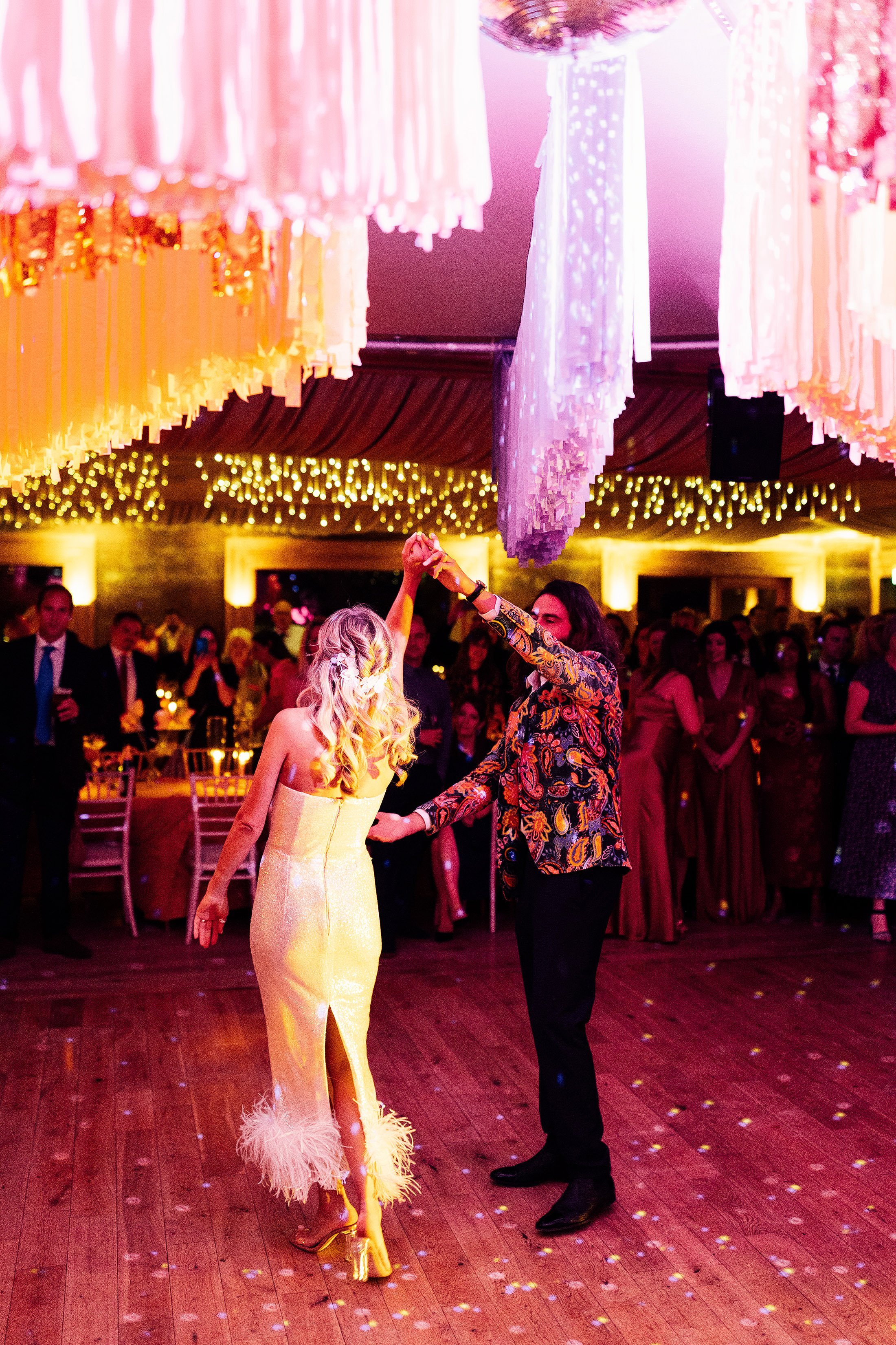 couple first dance at Elmore court with disco ball and colourful streamers 