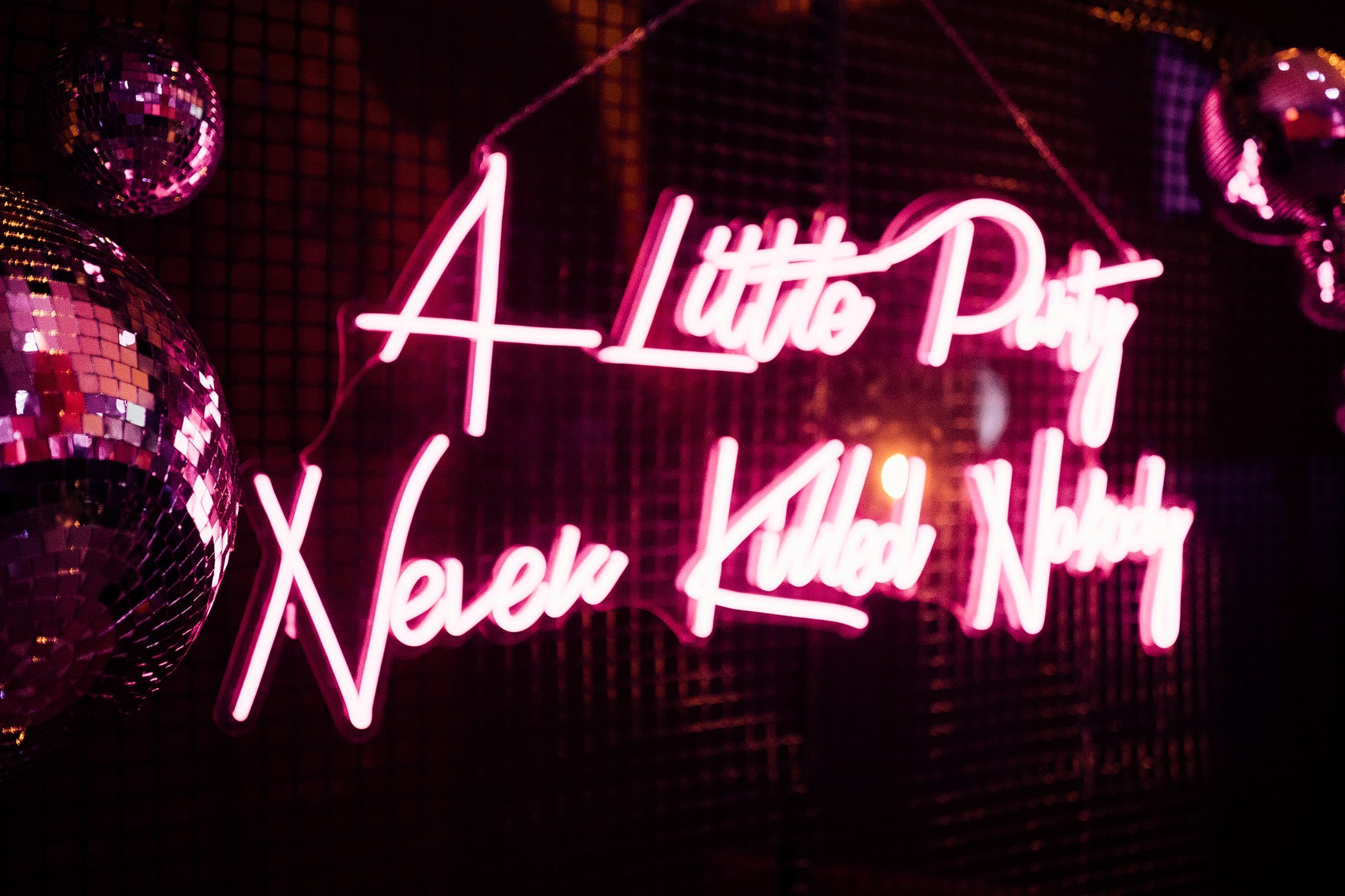 "a little party never killed nobody" neon sign.