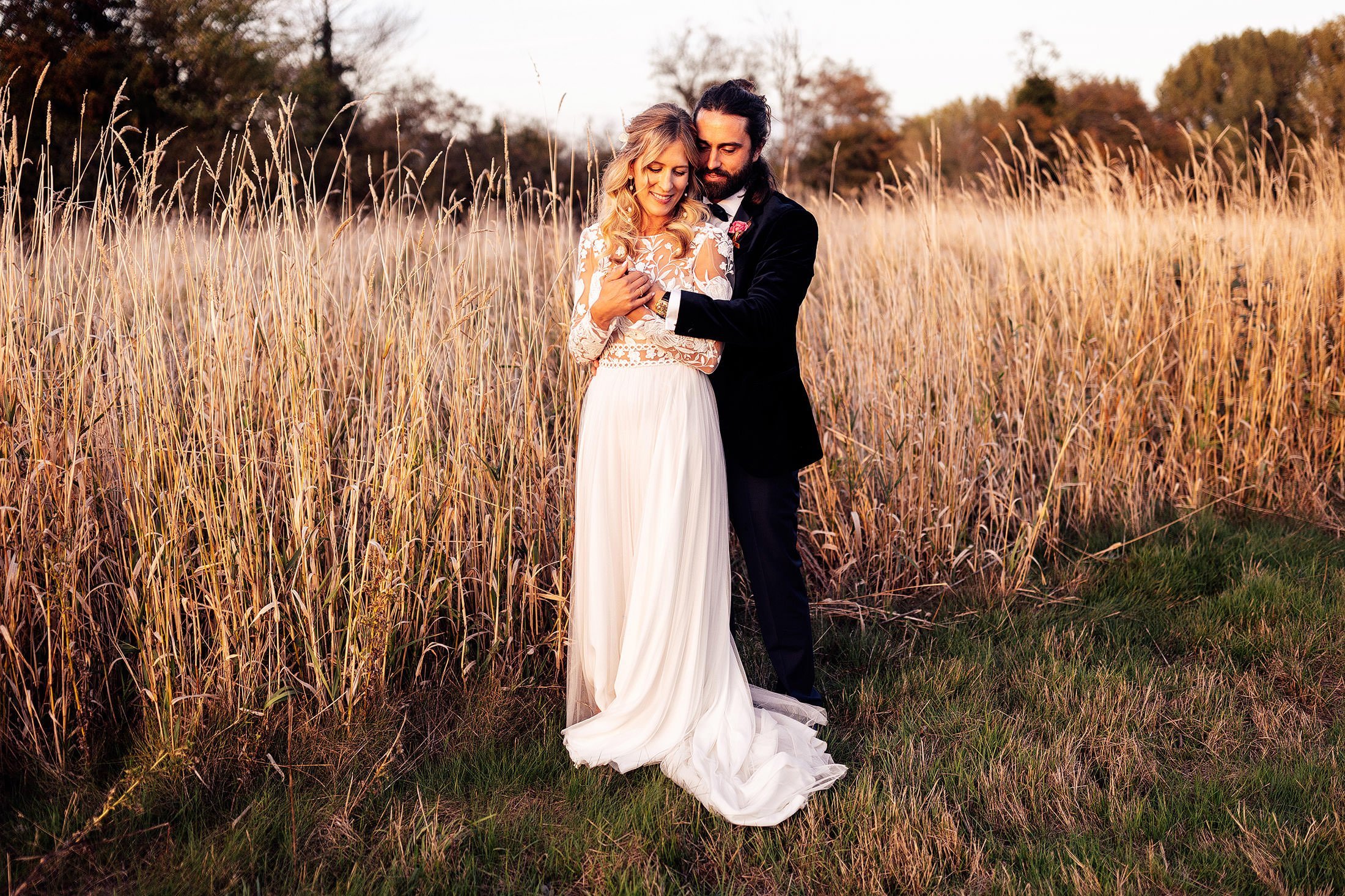 couple embrace in cotswold field during golden hour