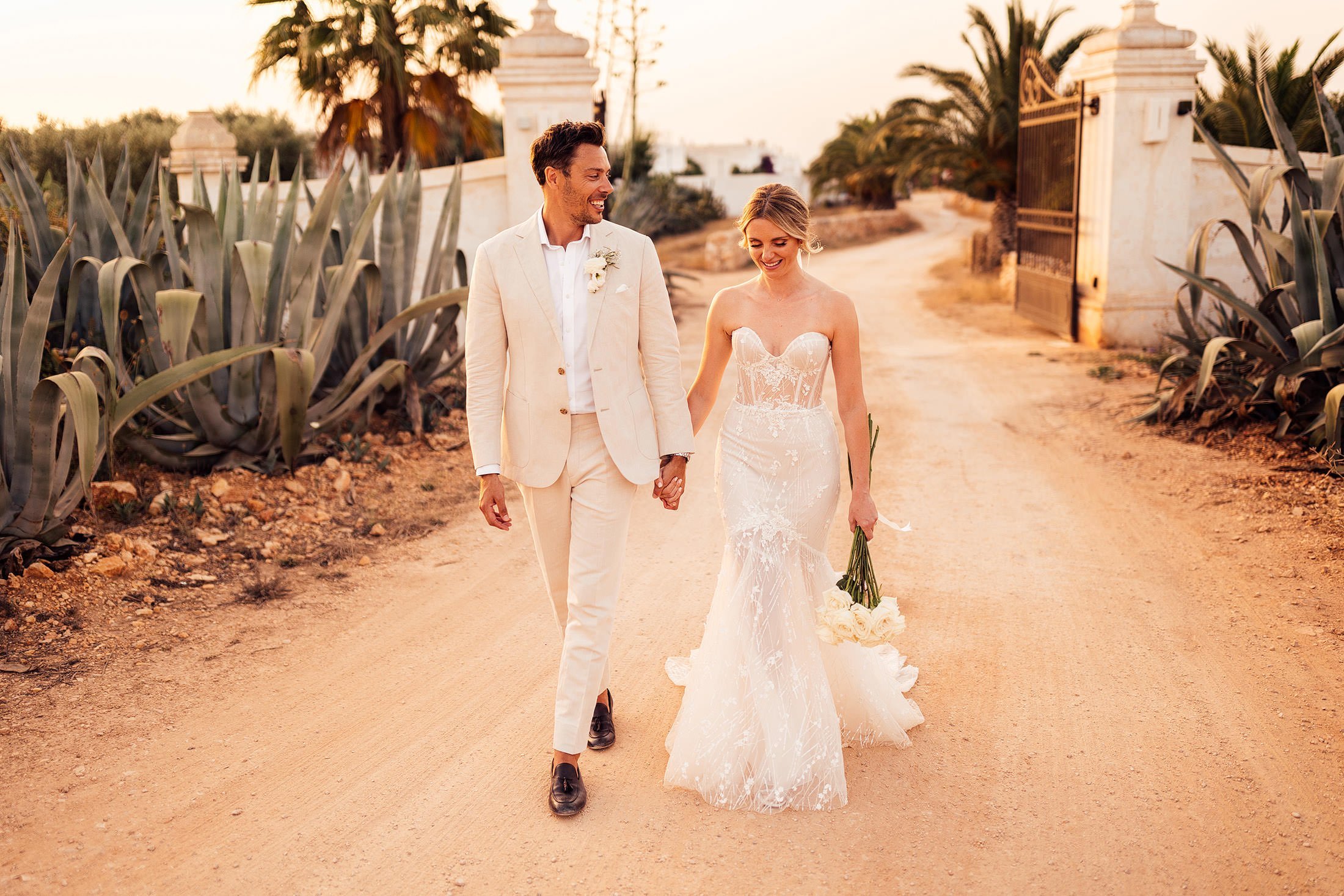 couple walk at sunset in classic Puglia wedding venue