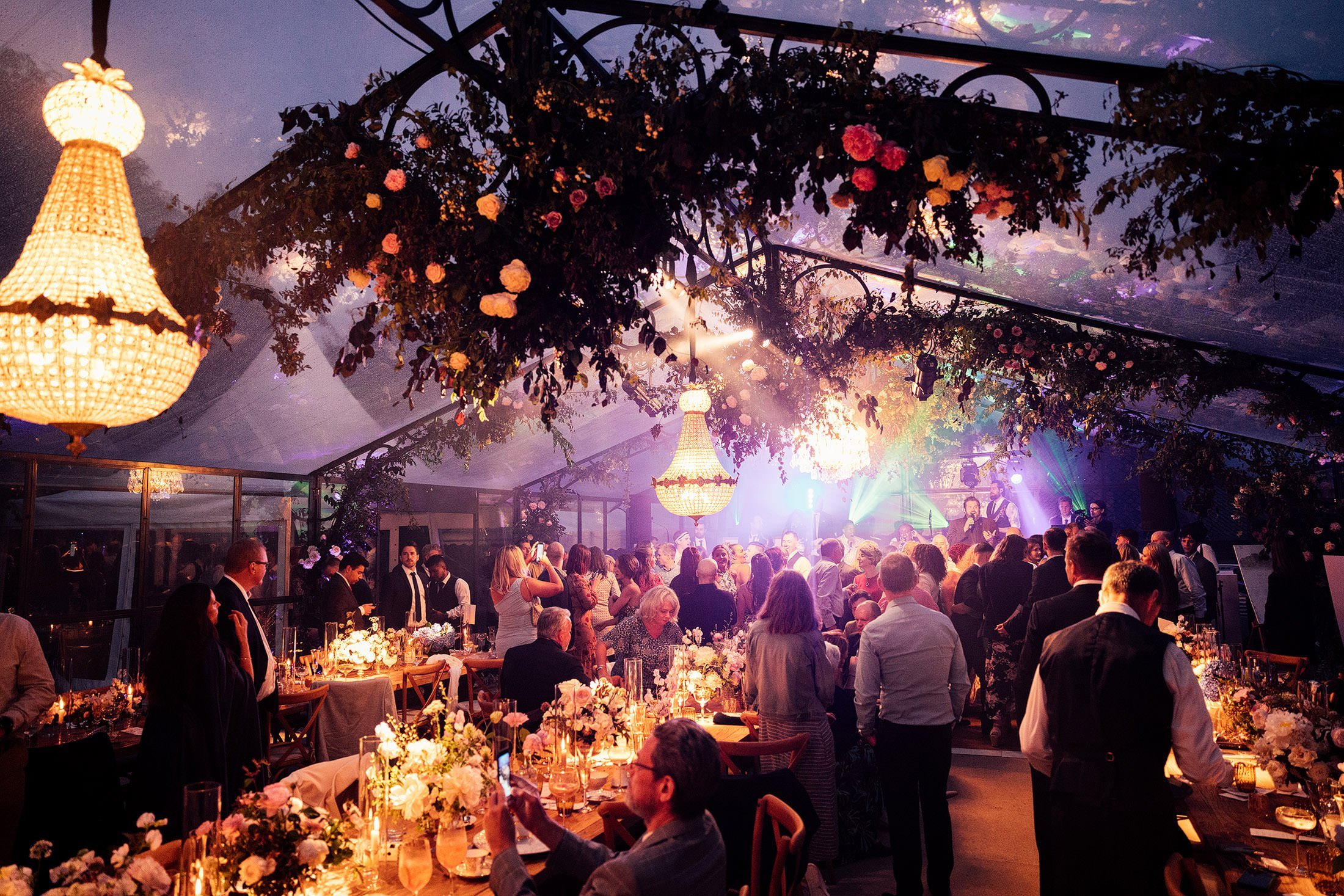 glass orangery marquee at night with disco lights