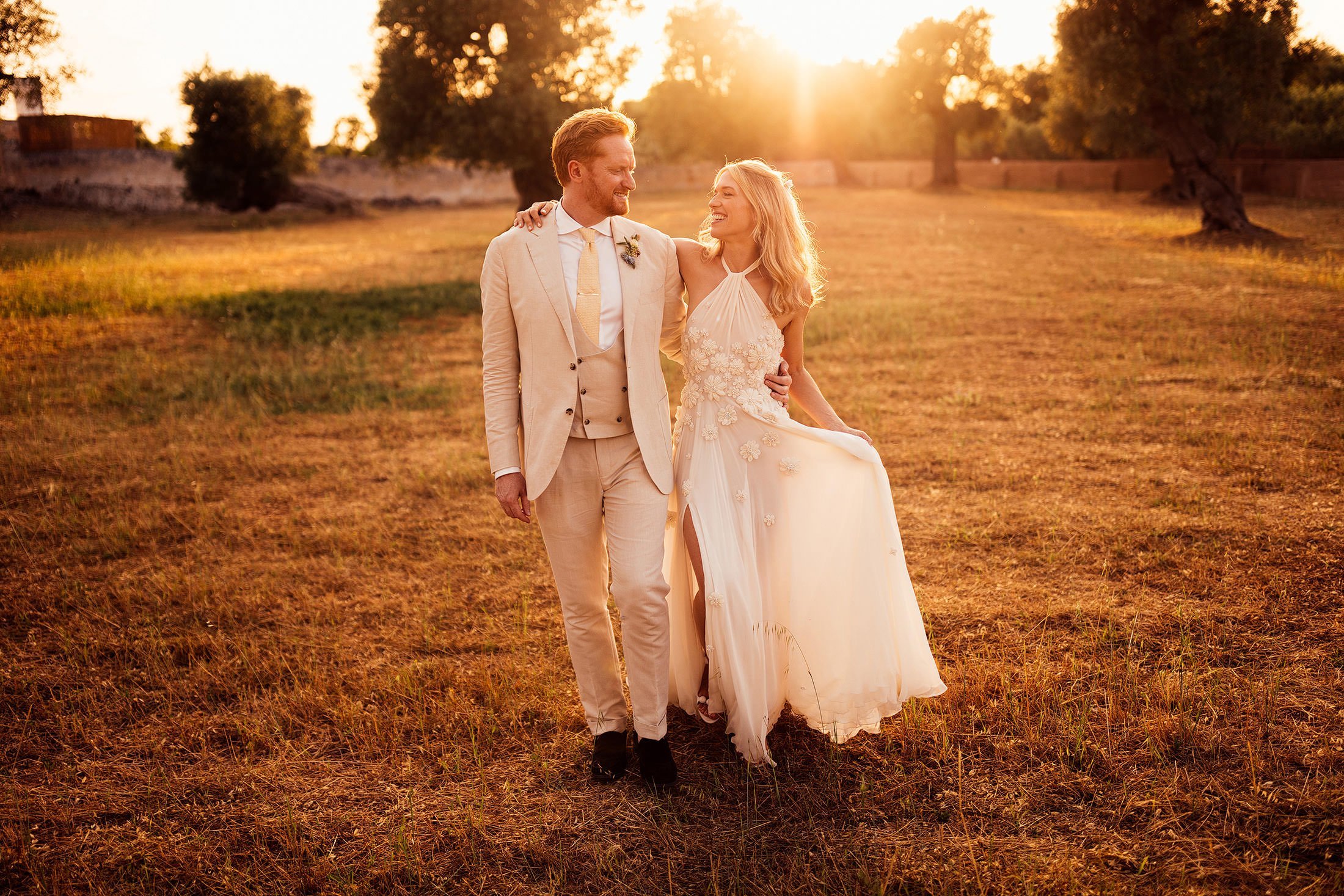 bride and groom walk in sunset at masseria mangiamuso