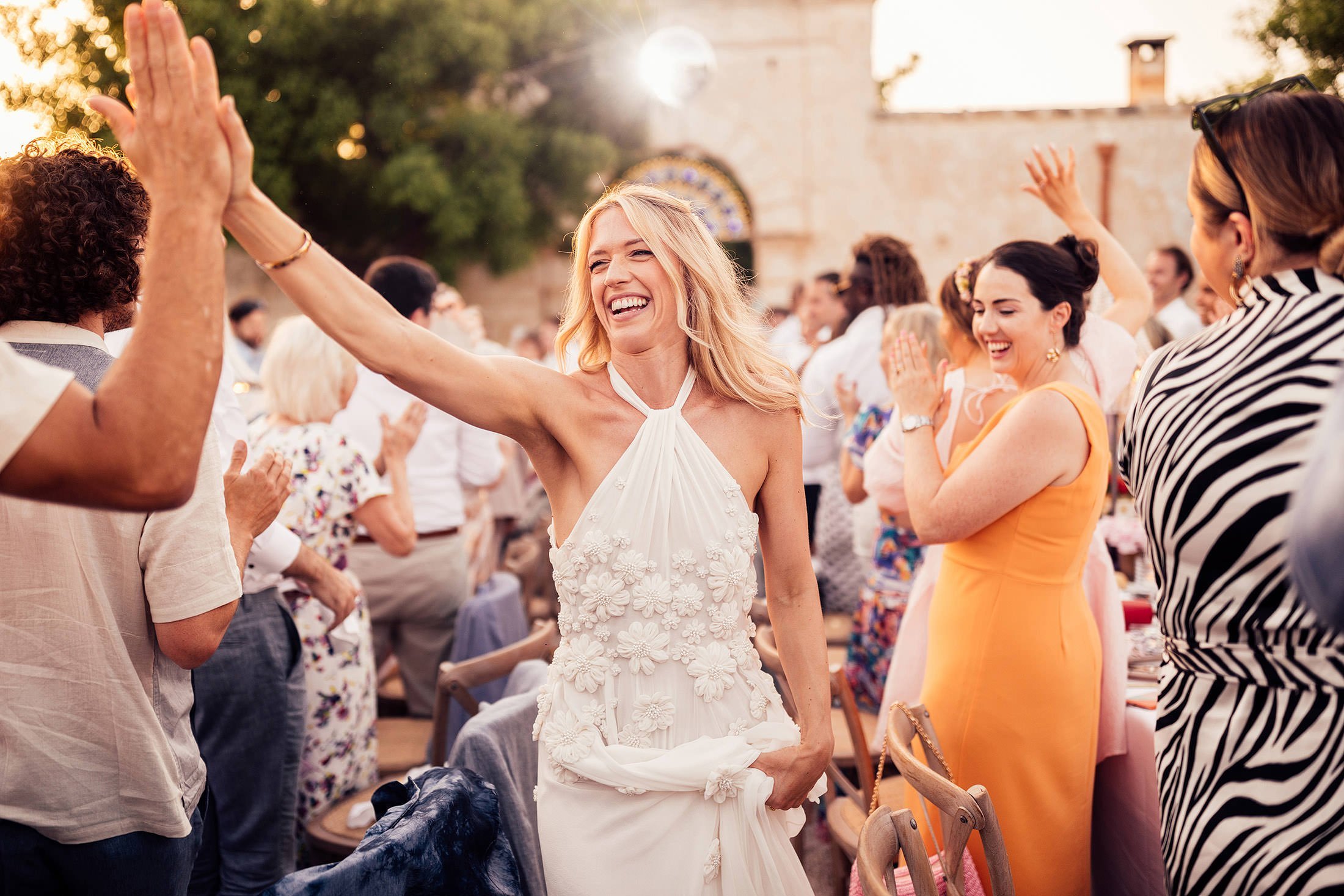 bride in Emma beaumont high fives guests on arrival