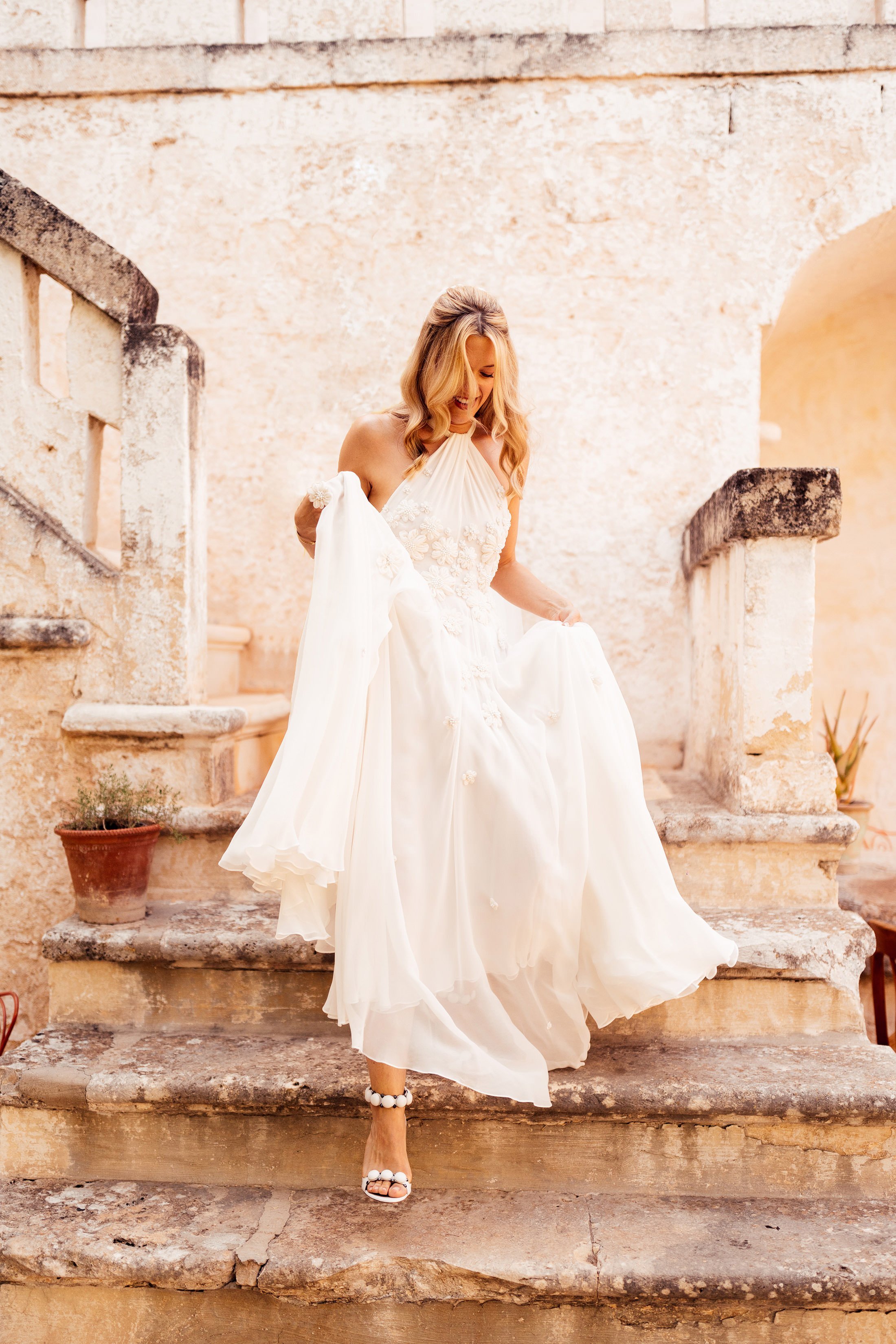 bride walks down stairs at masseria mangiamuso in bespoke floral Emma beaumont dress