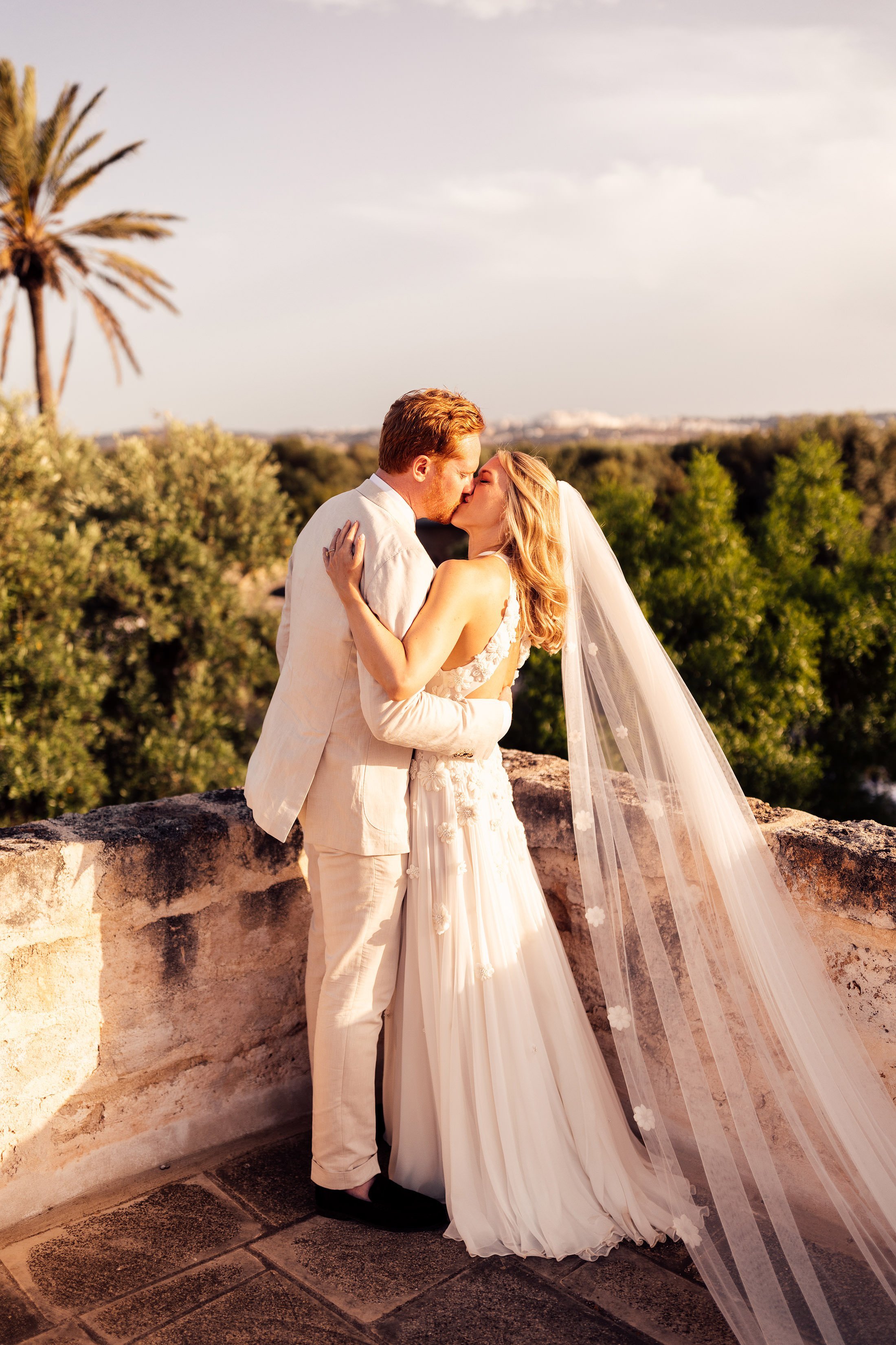 bride and groom kiss at top of masseria mangimuso