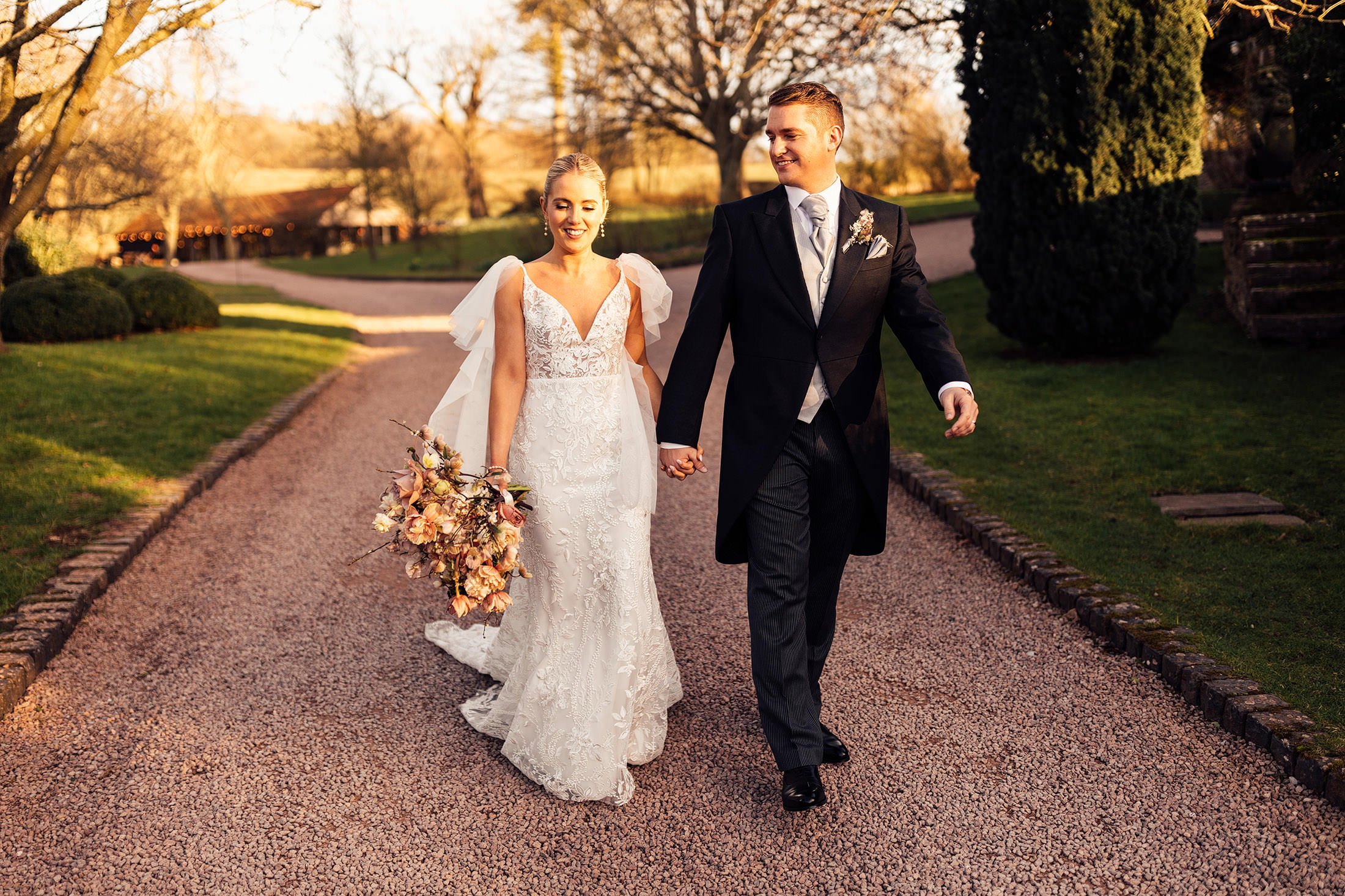 couple walk in sunshine at Hereford wedding venue
