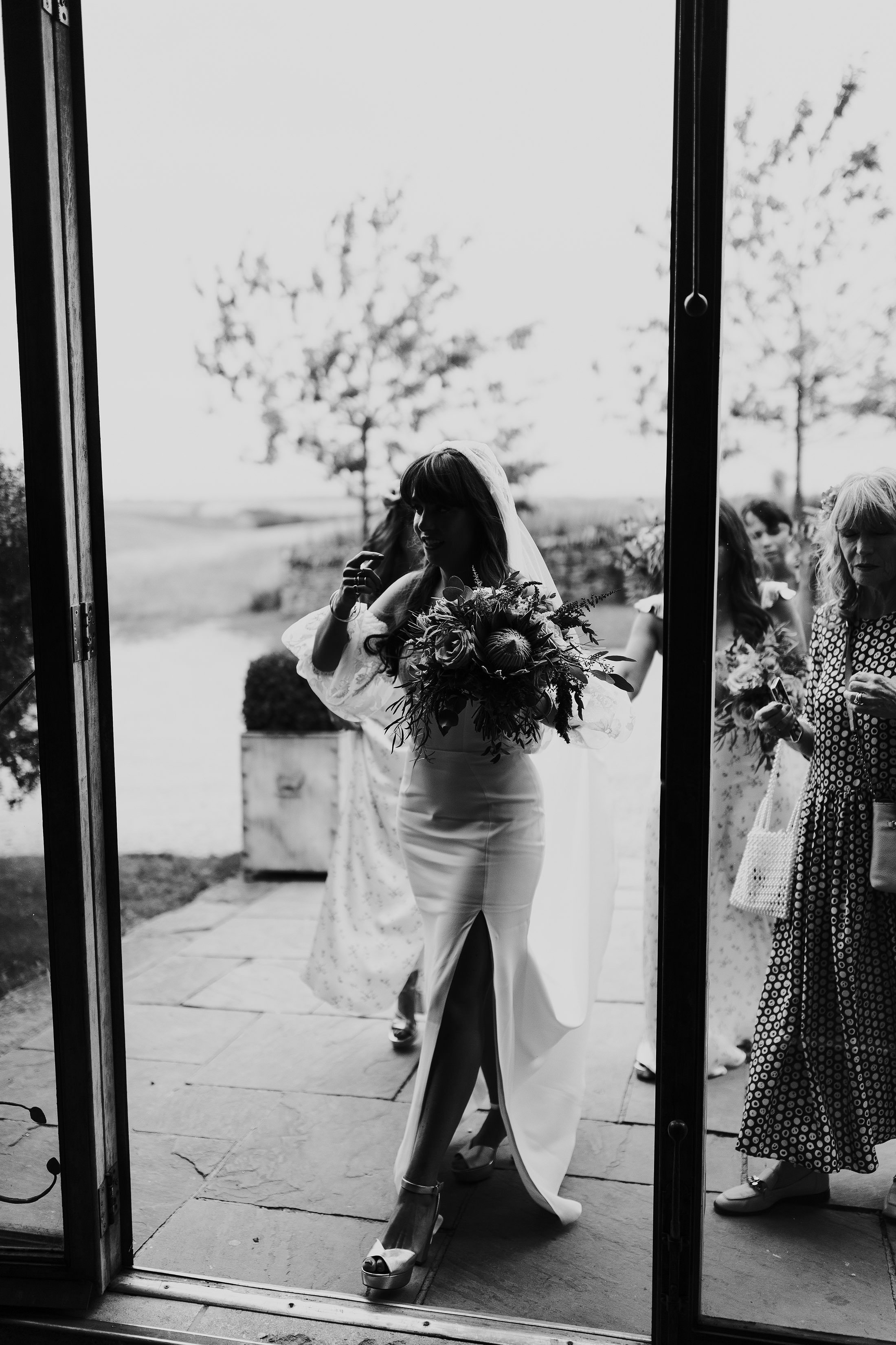 bride wears rime arodaky dress with detachable sleeves and lace embellished veil