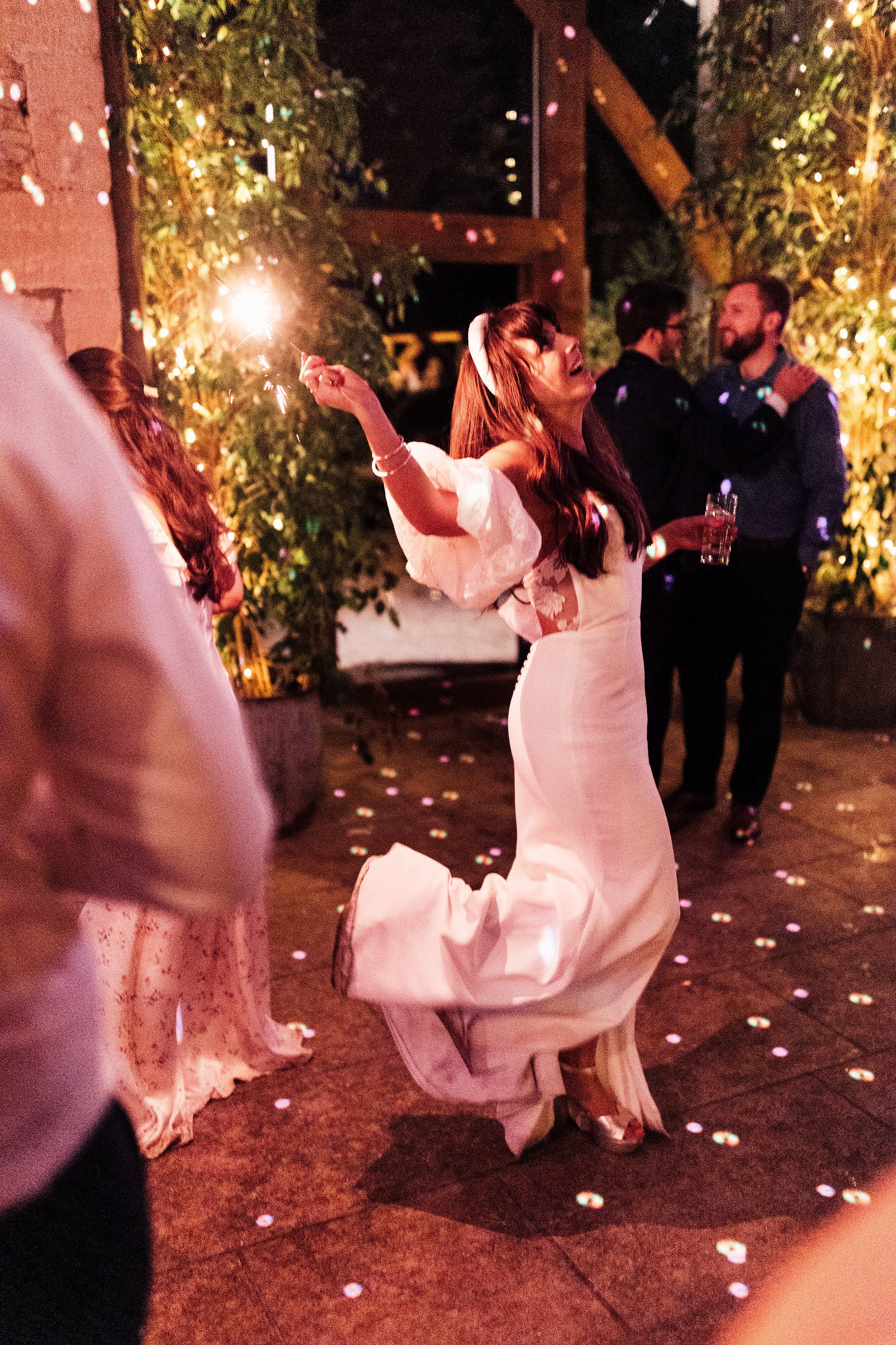 bride holding sparkler on dance floor