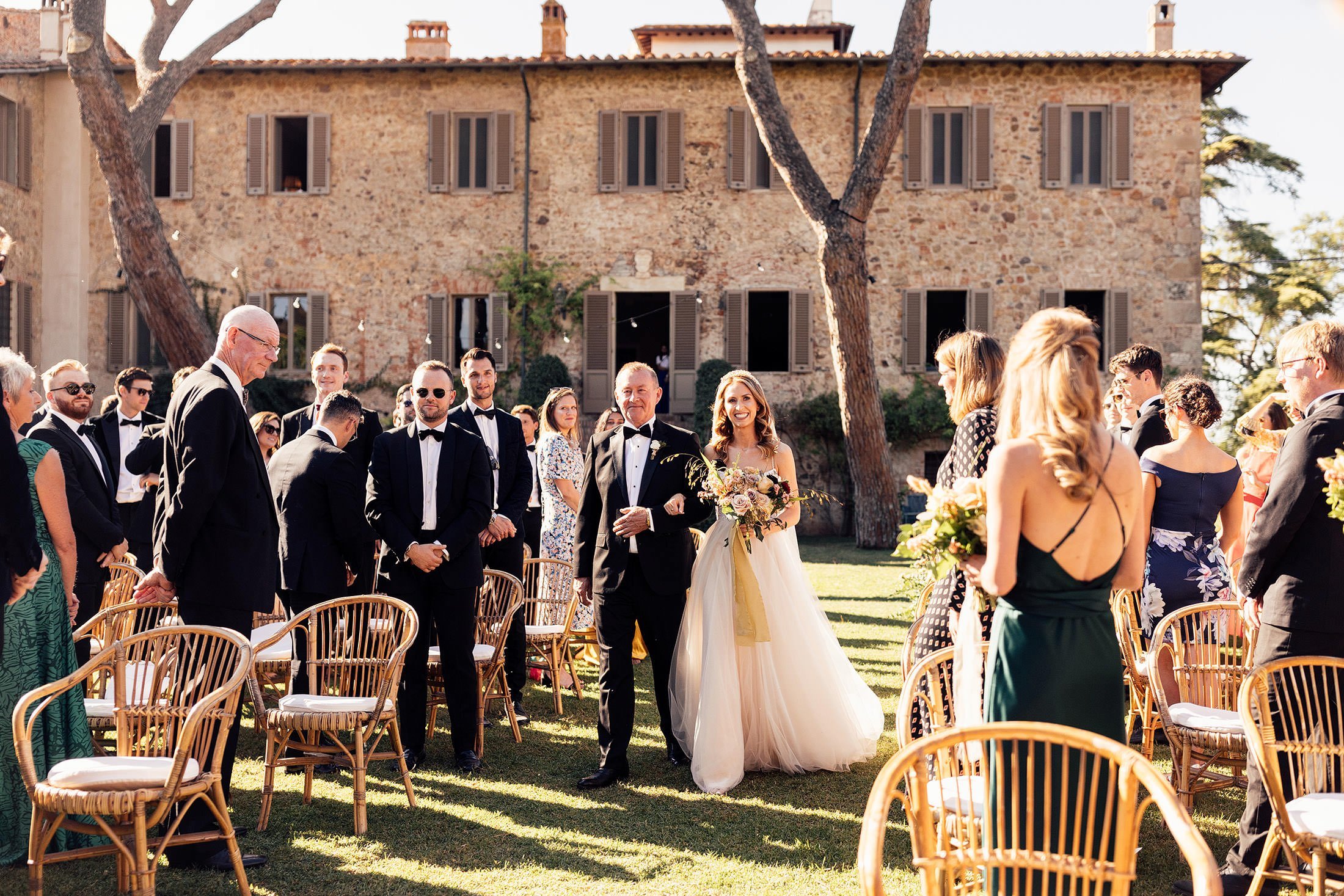 bride walks with father into outdoor Italian ceremony 