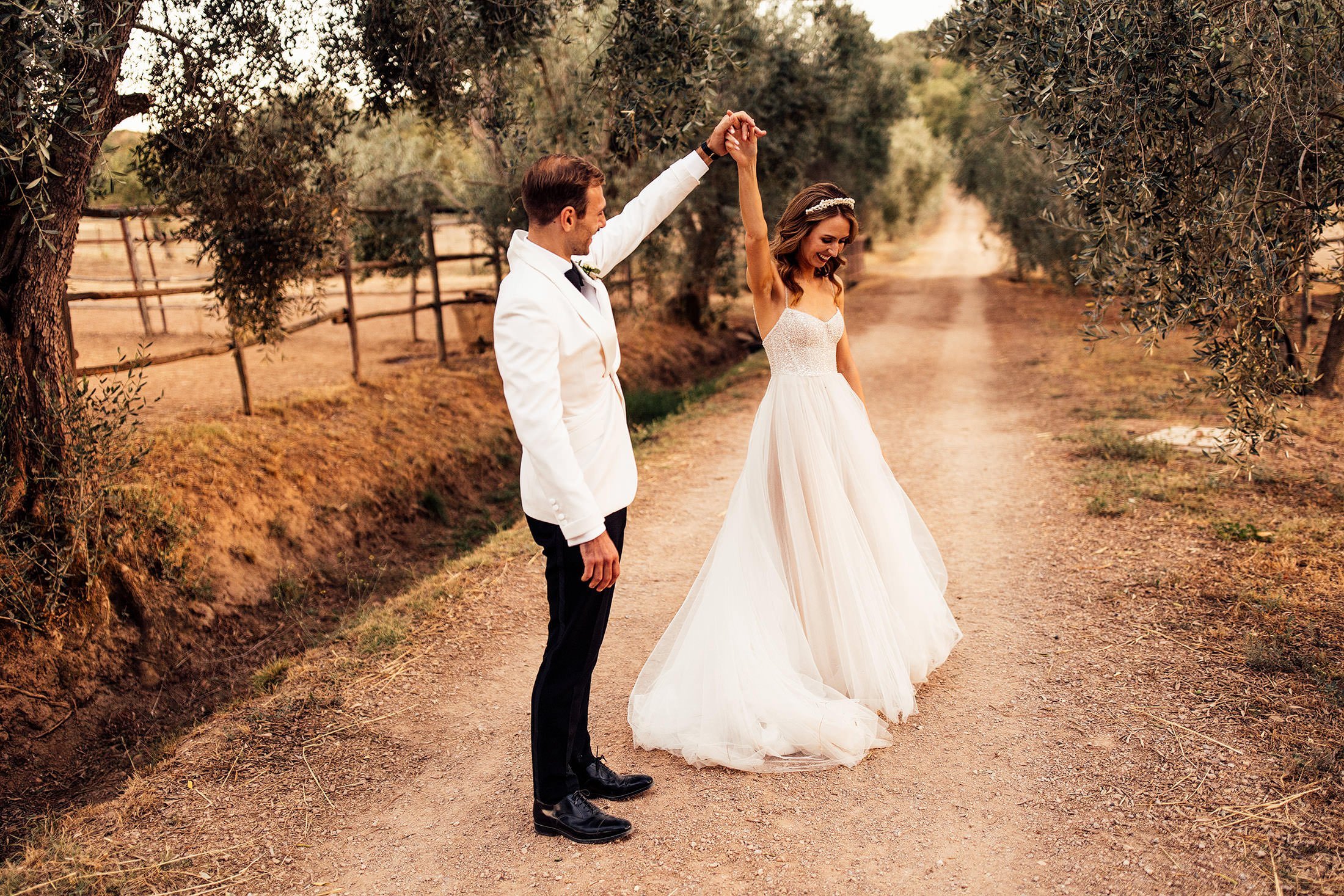 groom twirls bride in olive grove at la Pescaia resort