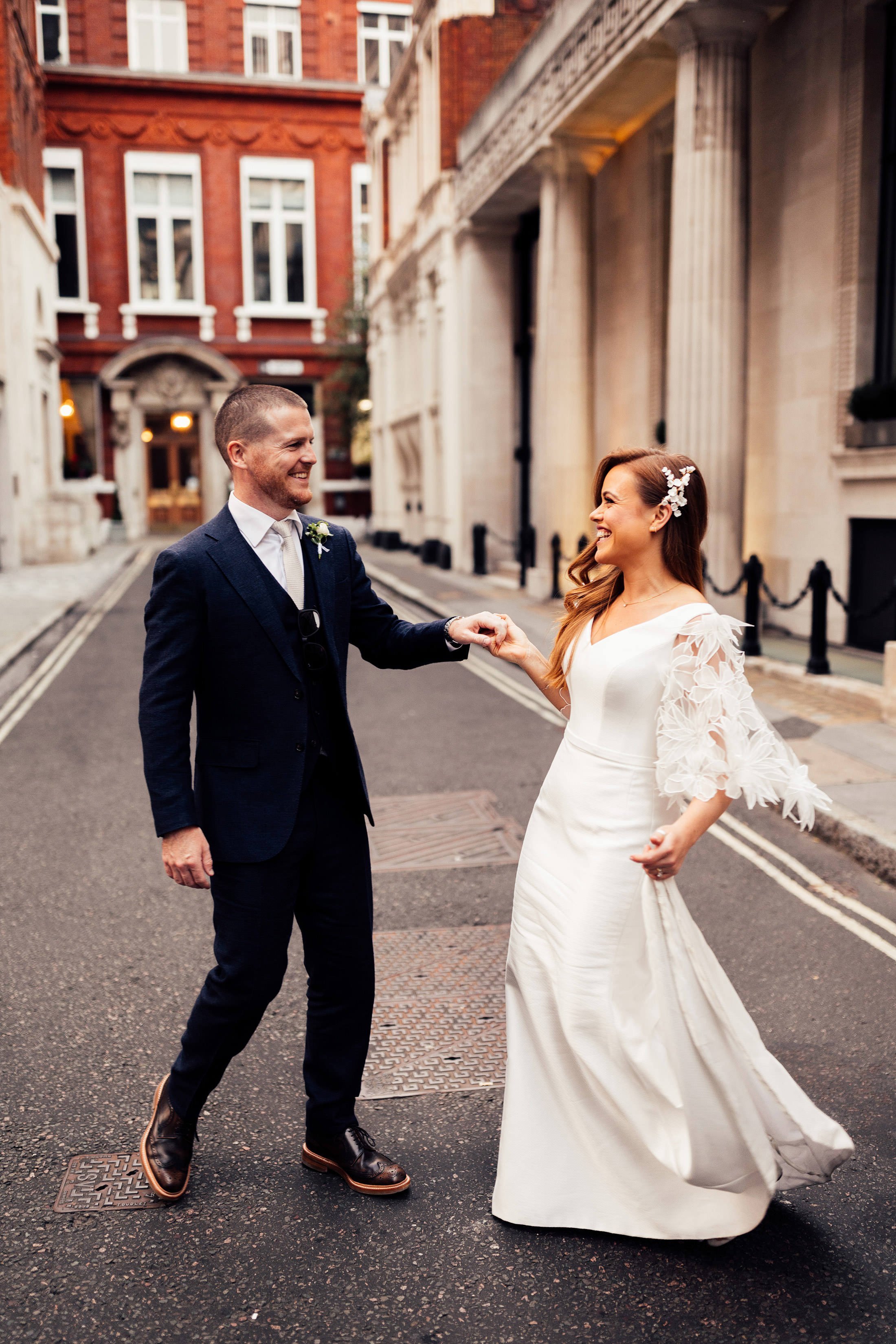 couple dance in London streets with bride in suzanne neville dress