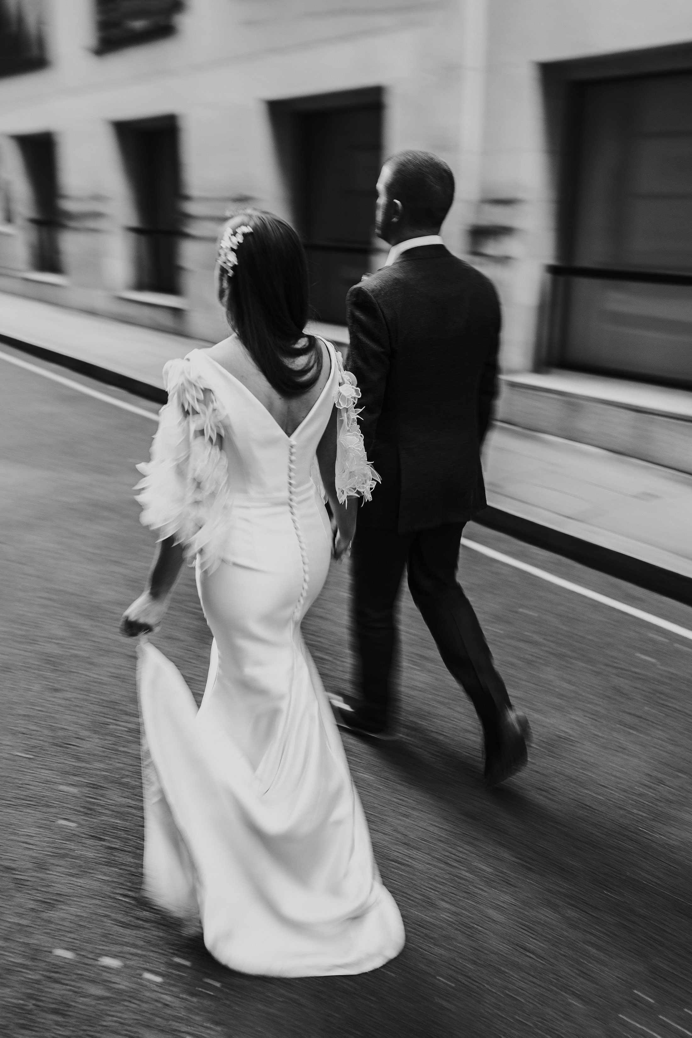 bride in suzanne neville dress walking hand in hand with groom