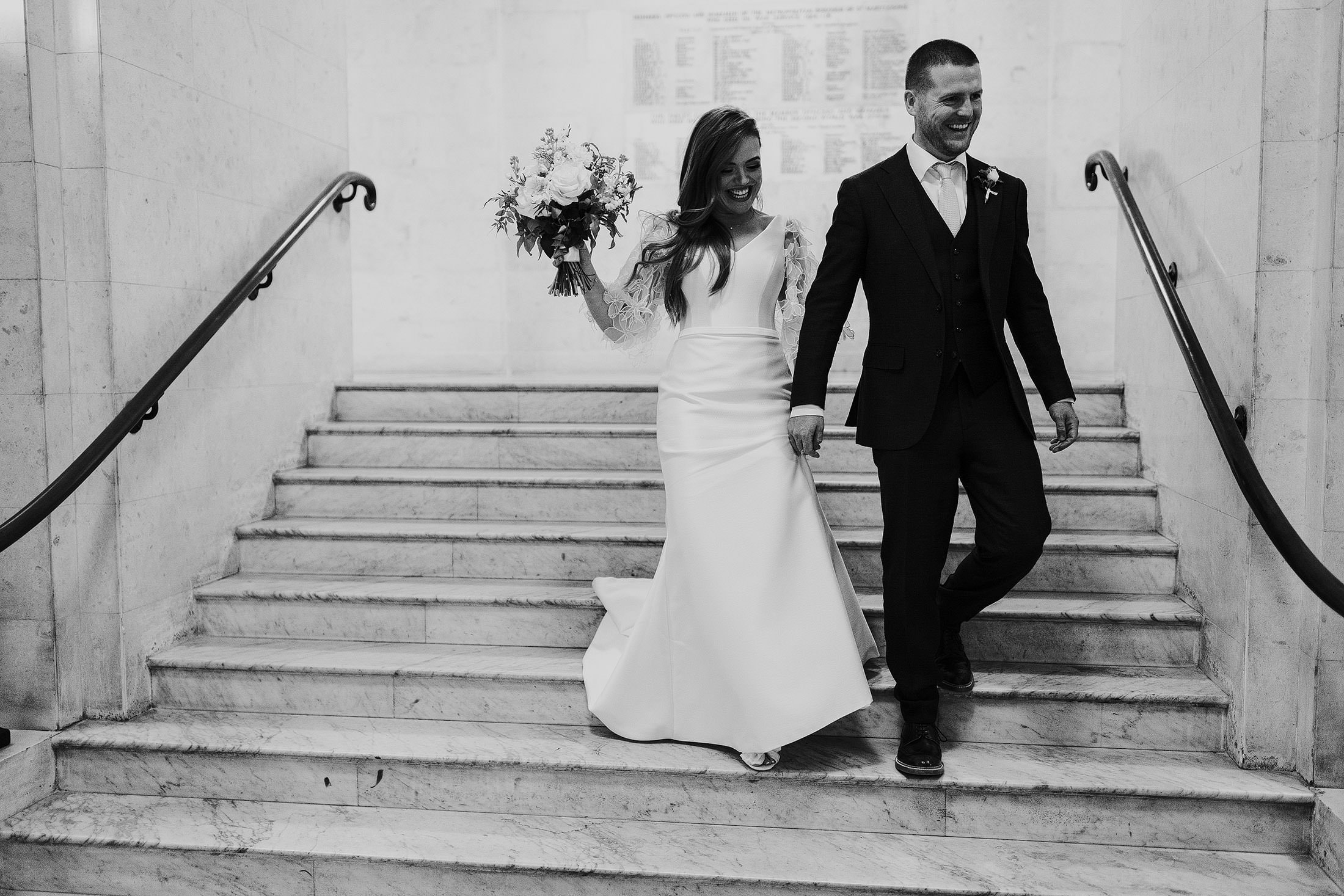 couple walk down Marylebone town hall stairs