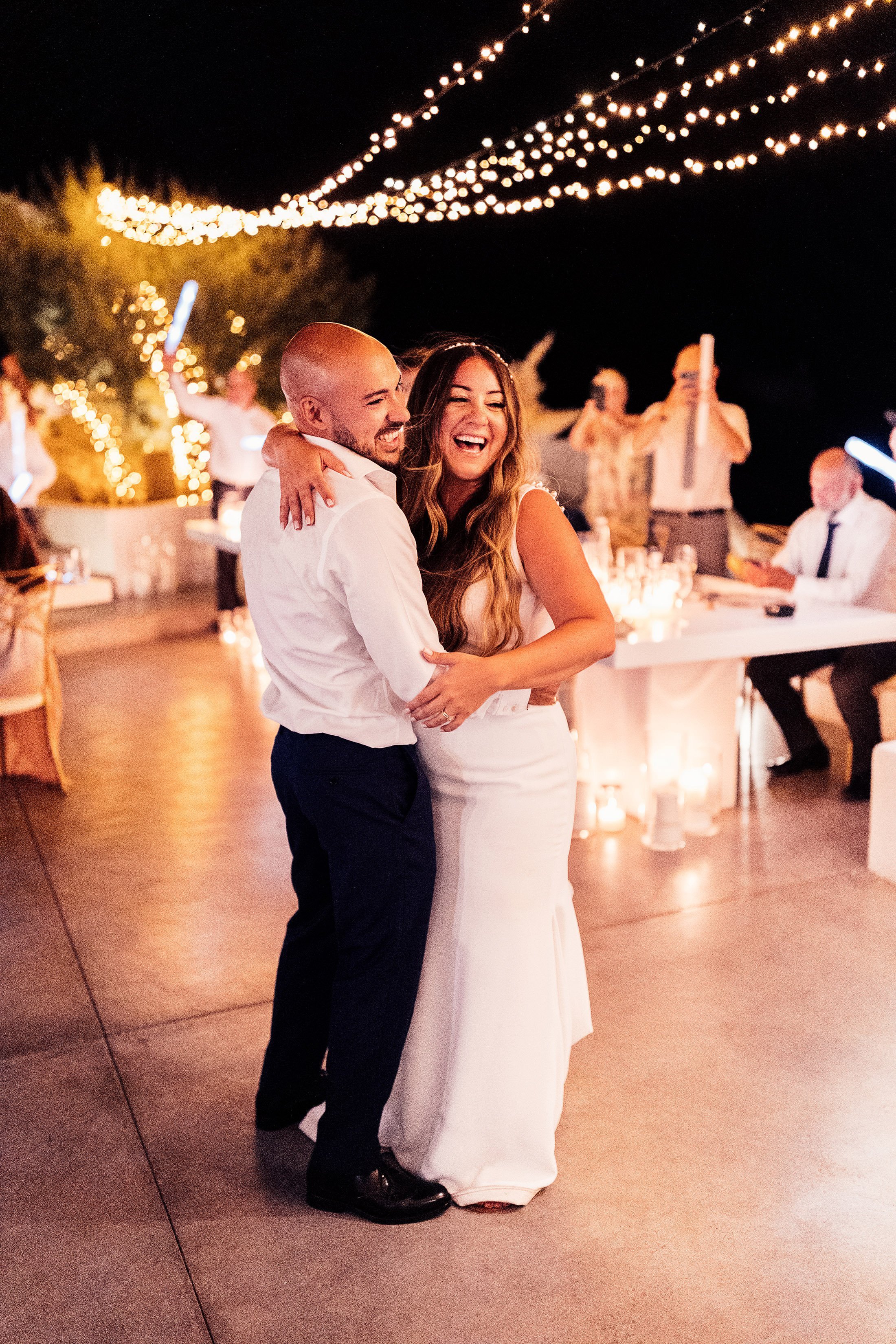 couple first dance under fairy lights in Greece