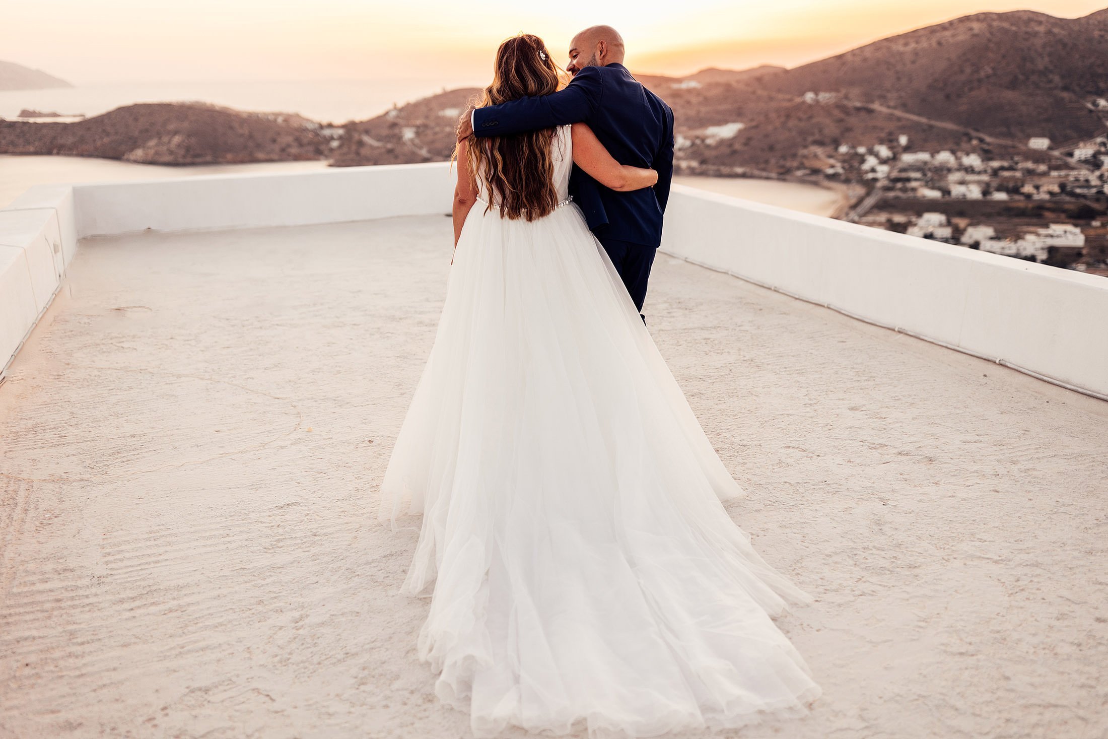 couple walk into sunset at ios club rooftop