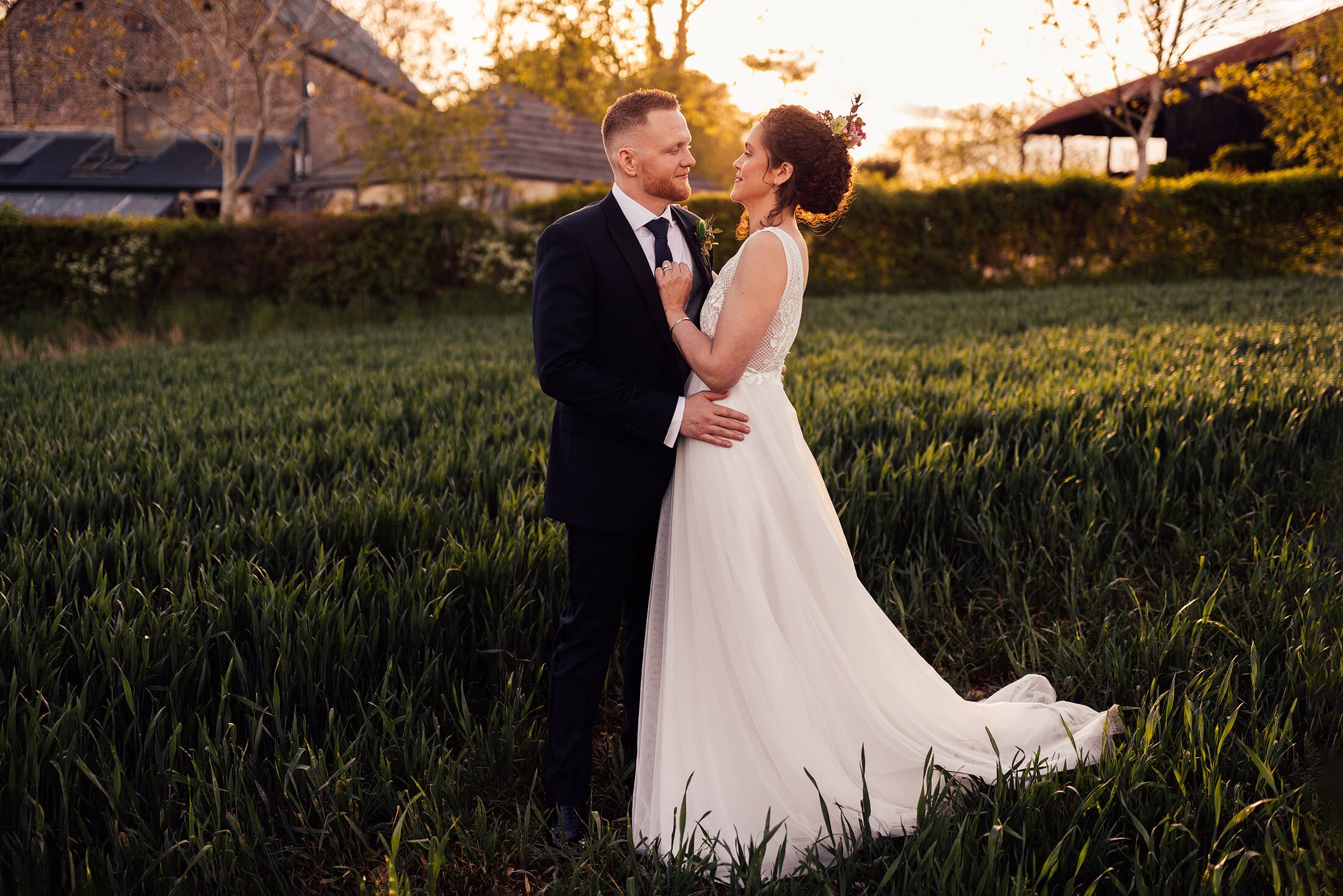 couple embrace at sunset in cotswolds