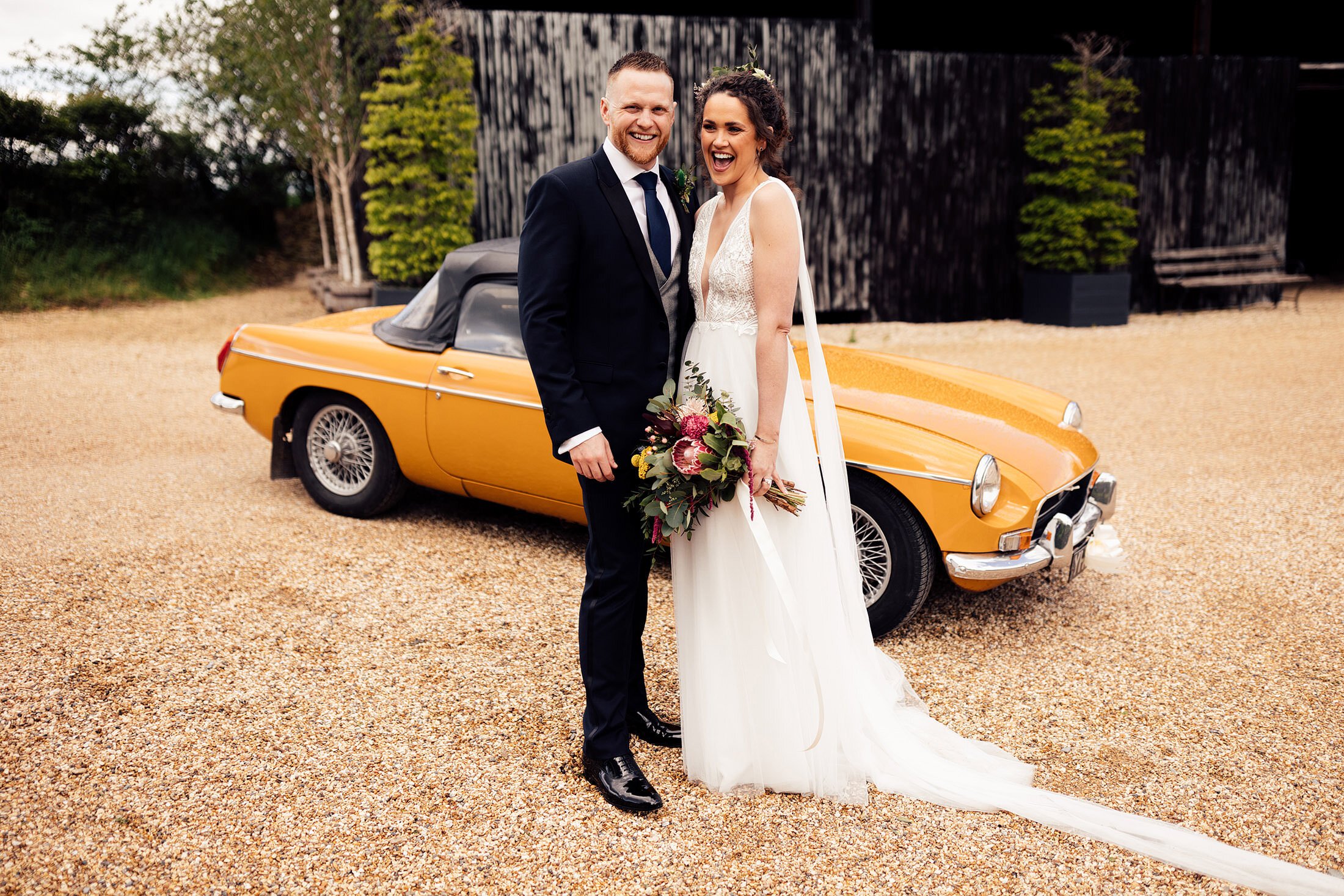 trendy couple in front of vintage car