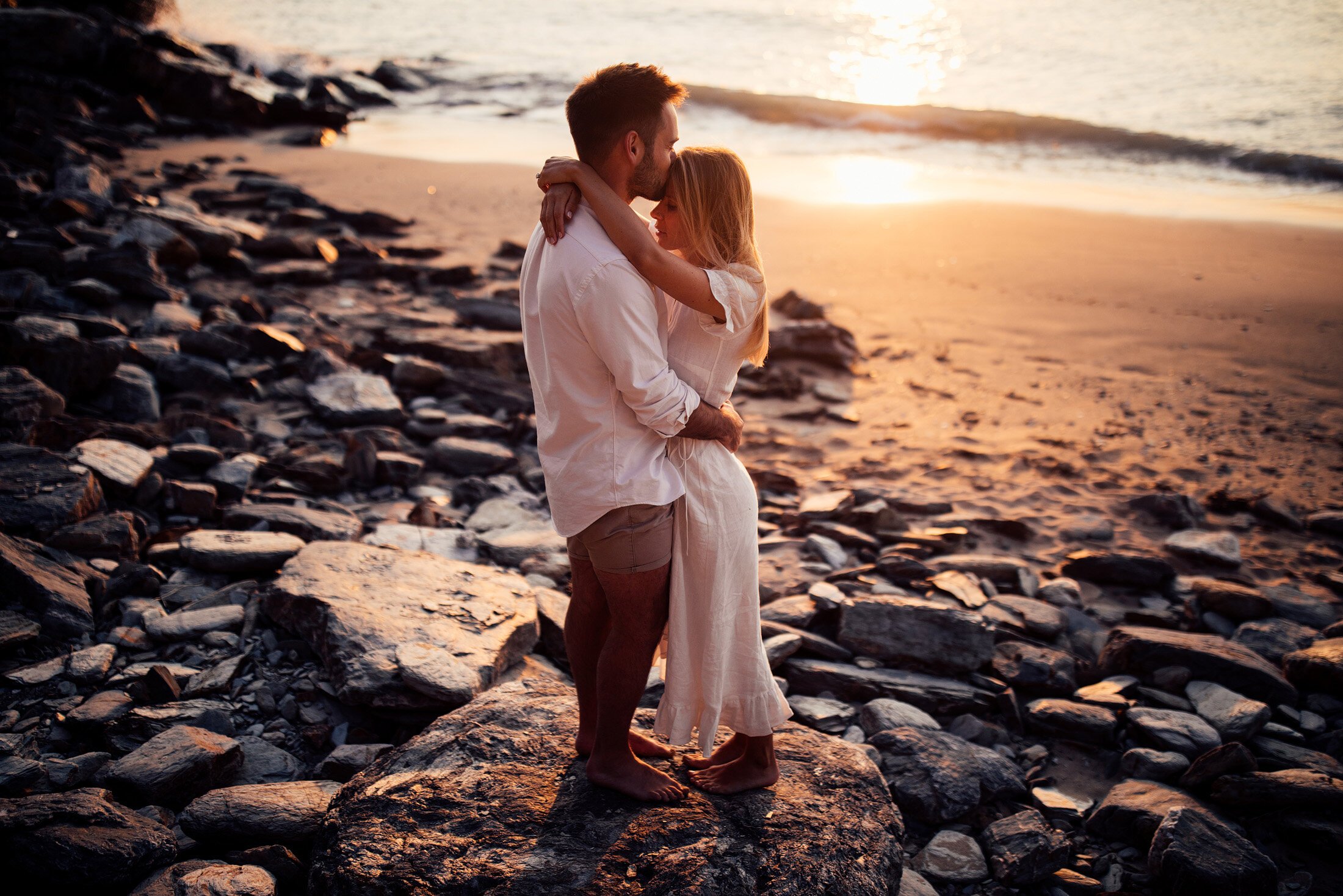 couple embrace at sunset on Cornwall beach
