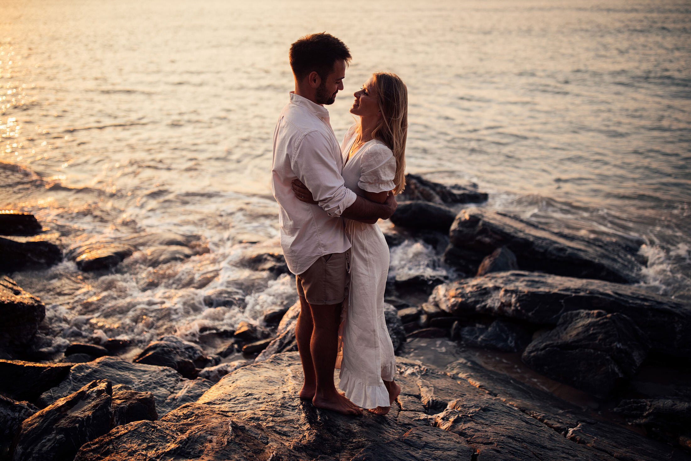 couple embrace on beach engagement shoot