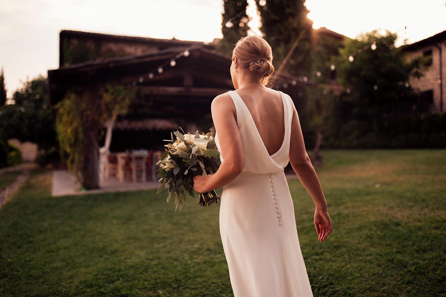 bride in pronovias in courtyard of borgo corsignano italy