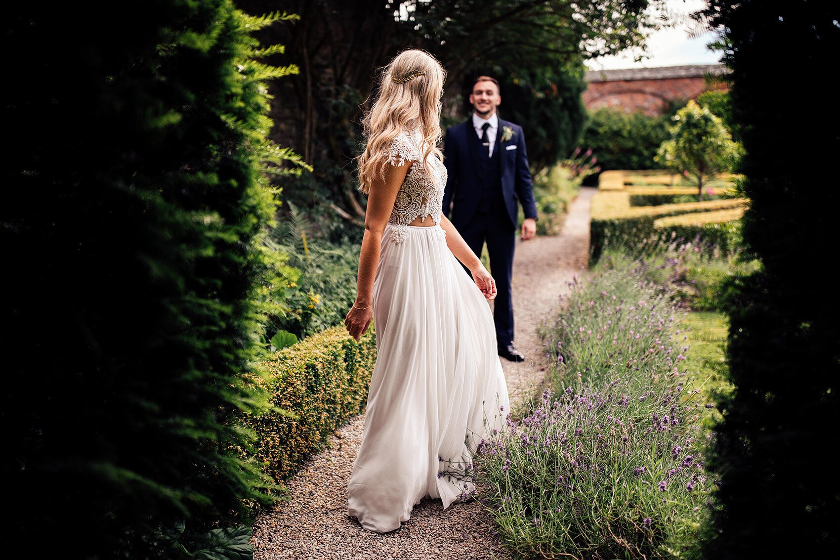 Bride in Julio Vino wedding dress walking through the gardens at Kingston Estate, Devon