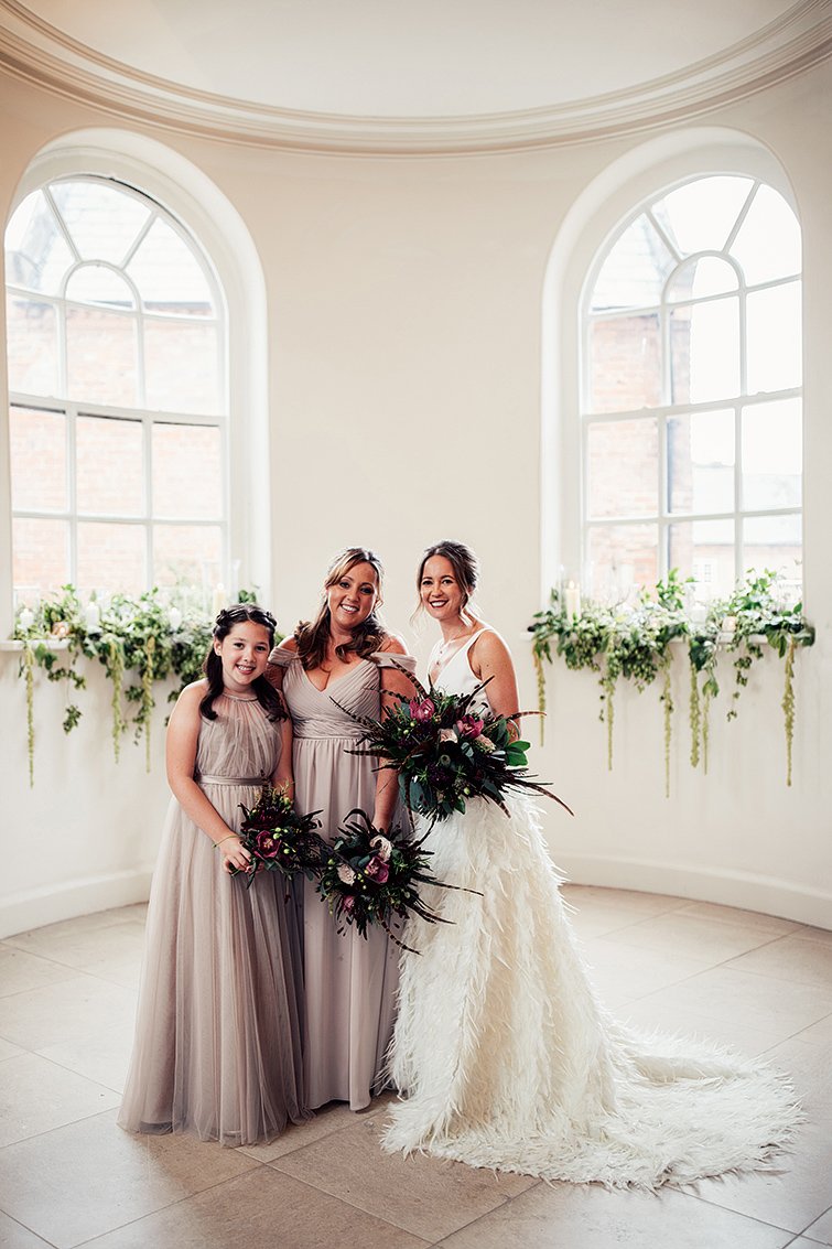 bride in bride in Charlie Brear Payton gown &amp; Piora feather skirt with bridesmaids