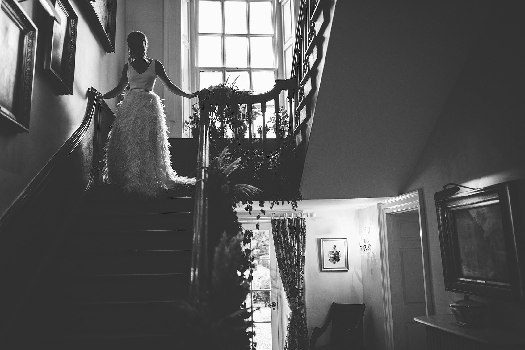 bride in bride in Charlie Brear Payton gown &amp; Piora feather skirt walks down stairs