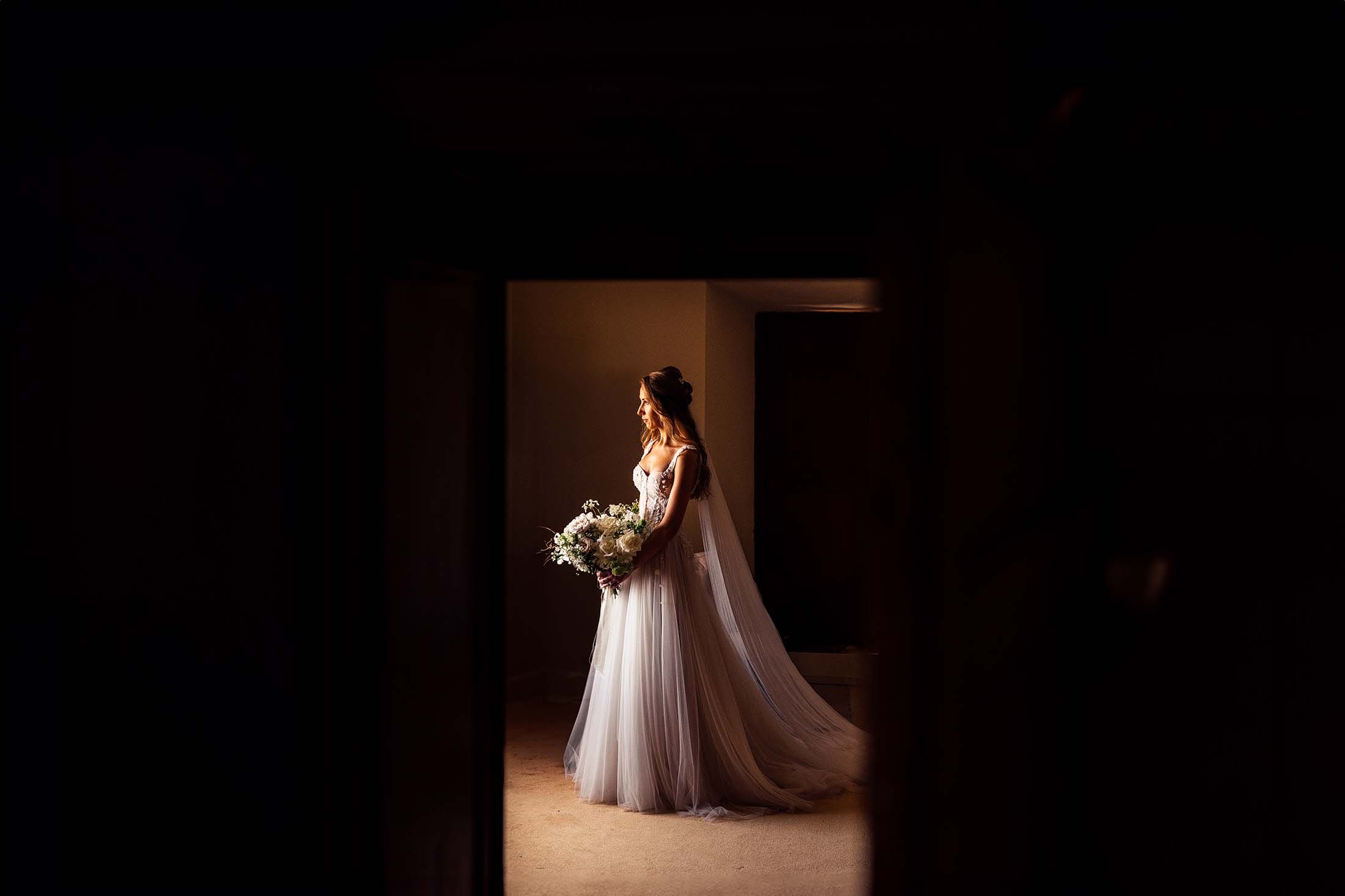 bride poses for photo in italian wedding venue