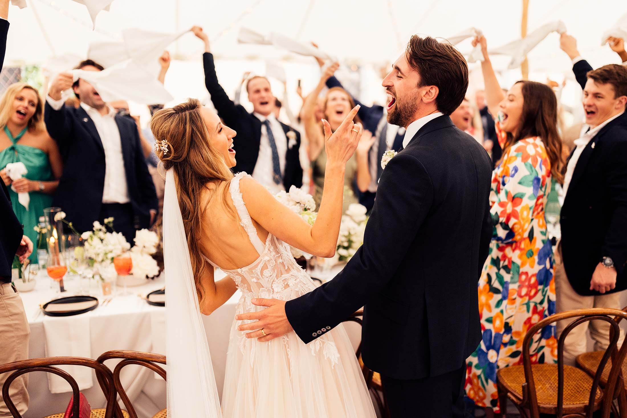 couple arrive at destination wedding reception with guests dancing in background