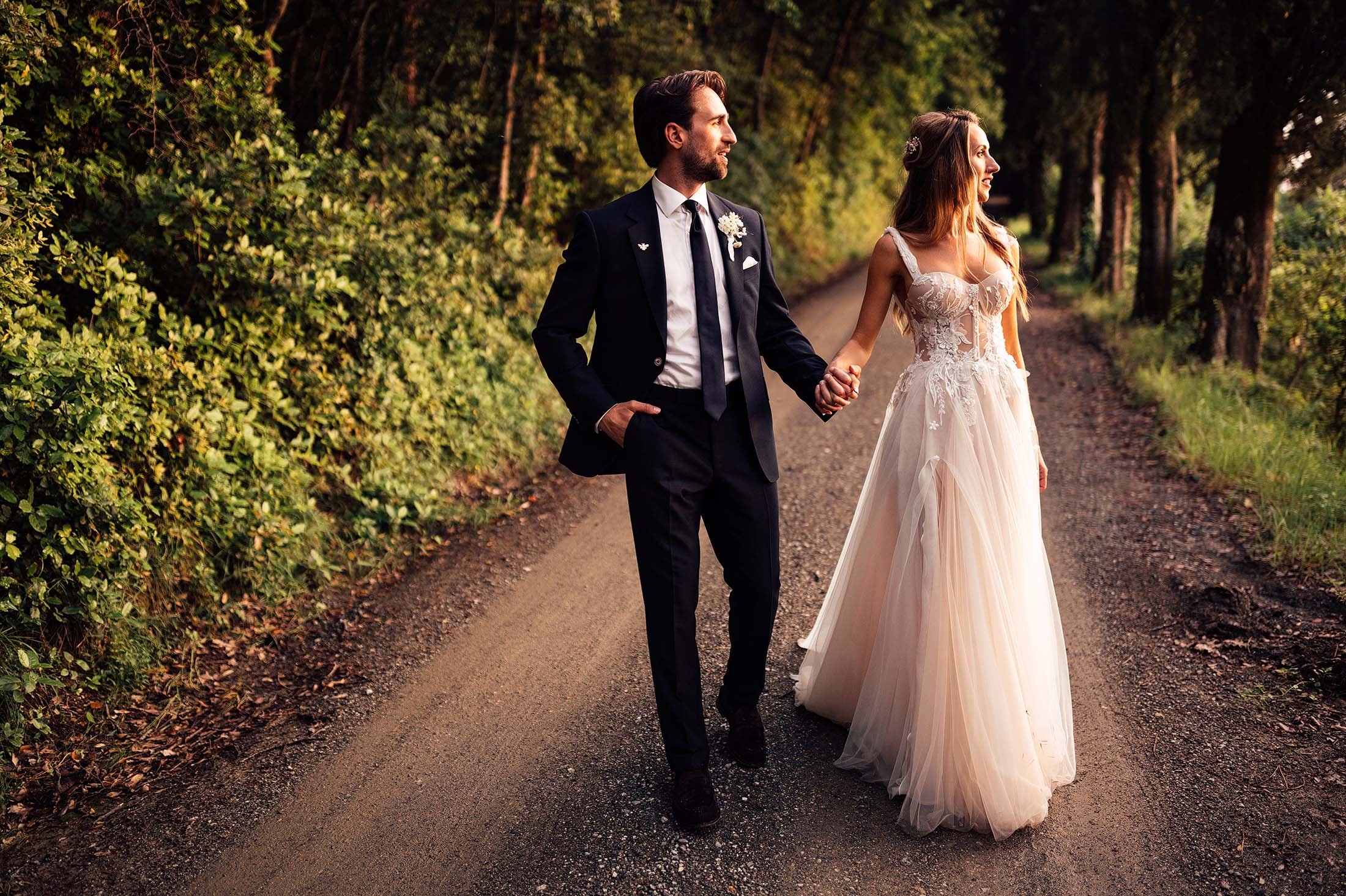 couple walk during sunset with bride in muse by berta dress