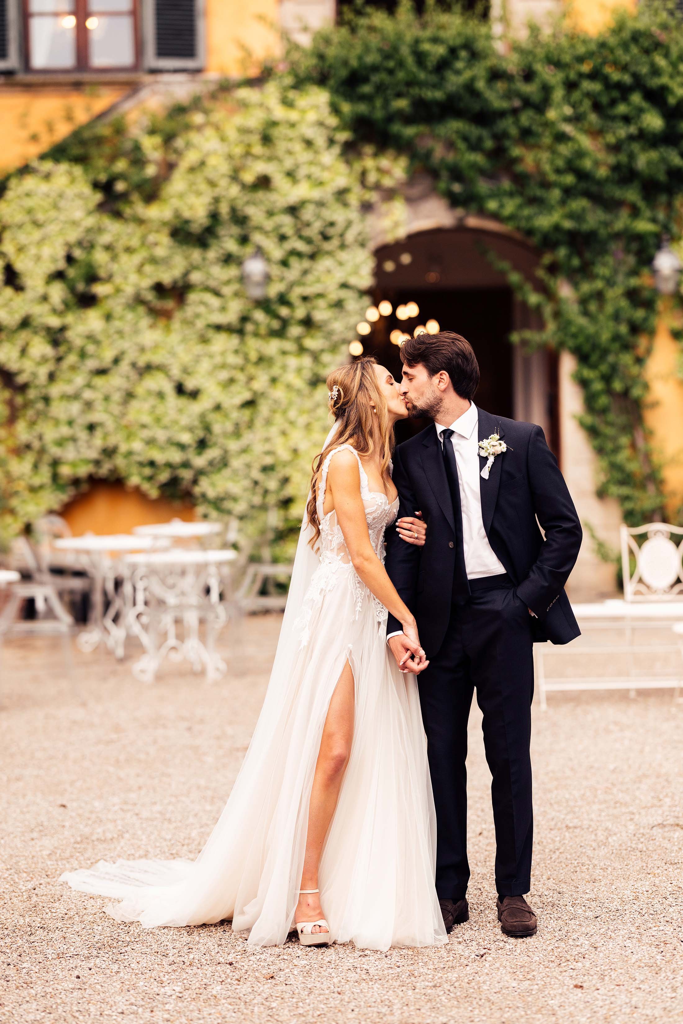bride and groom kiss outside italian wedding venue 