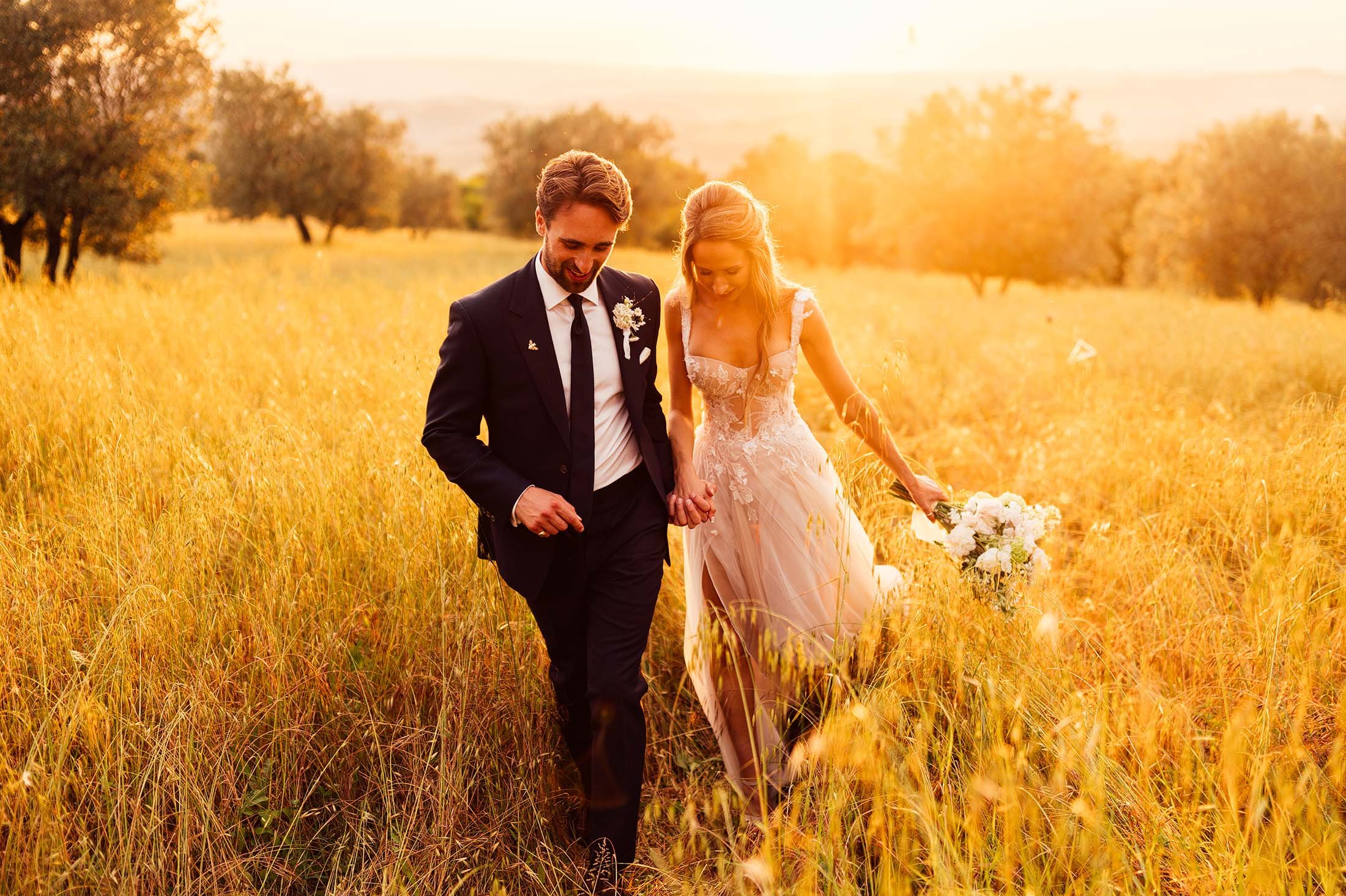 bride and groom embrace in olive grove during tuscany sunset