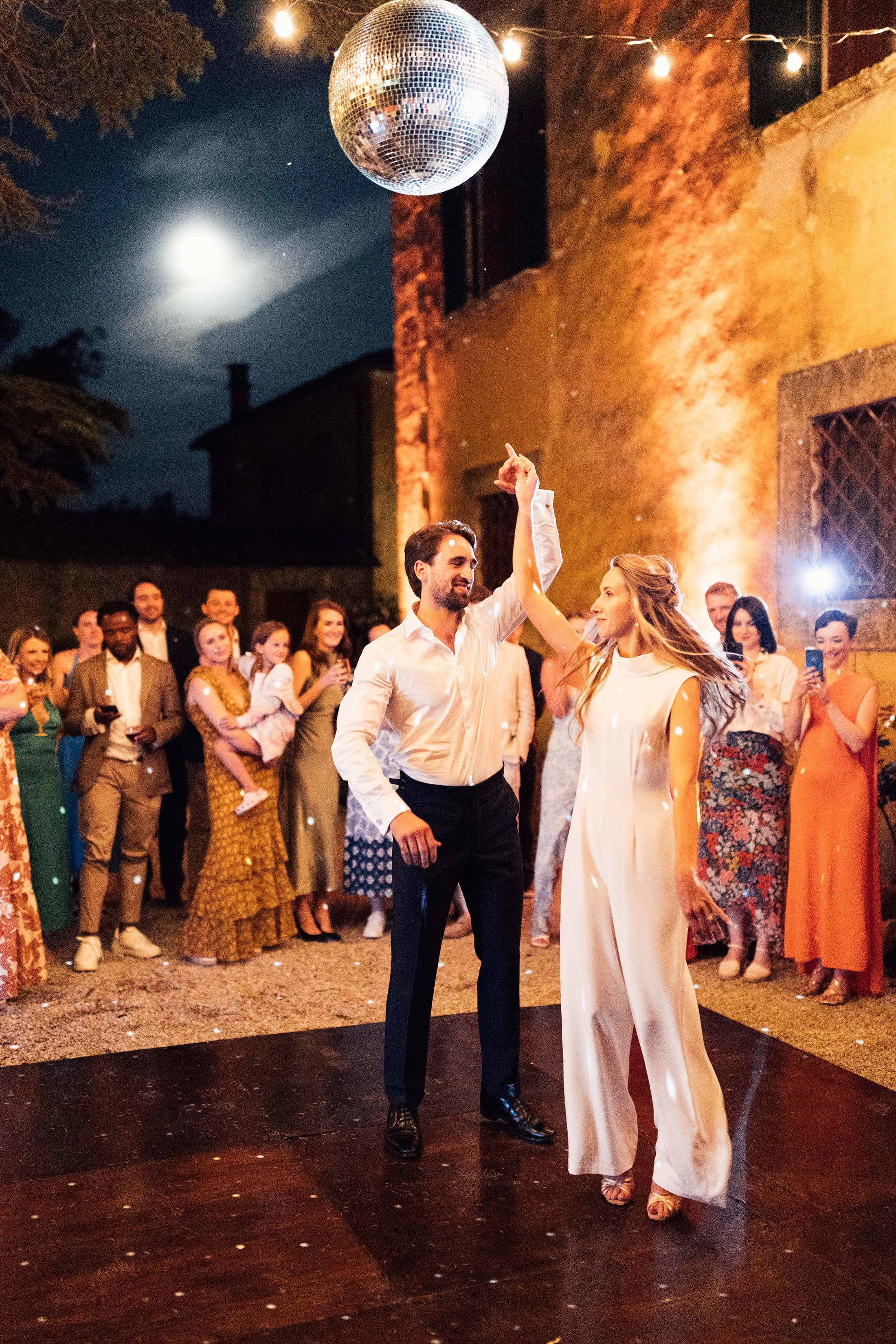 couple perform first dance with disco ball above