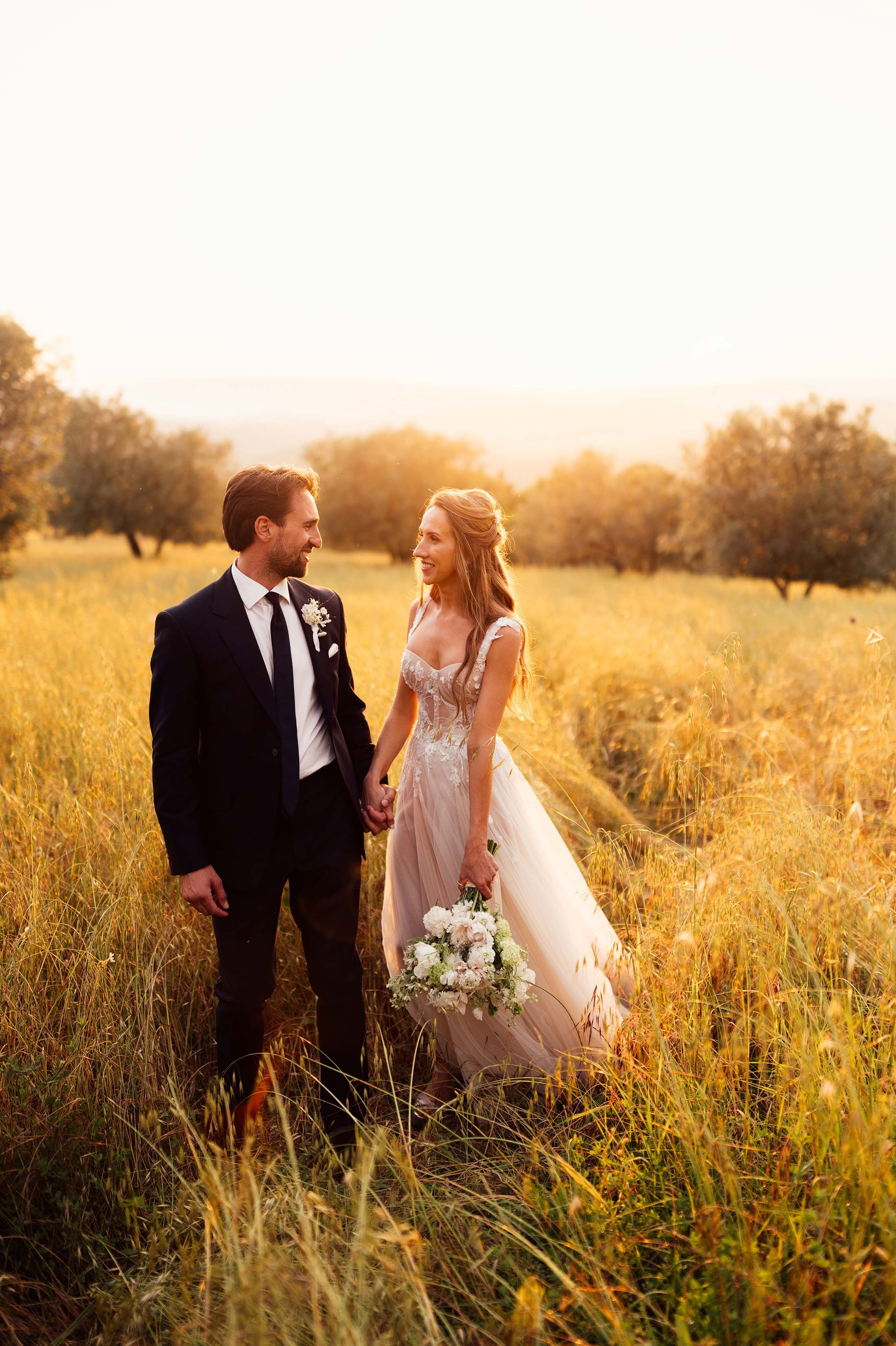 Bride and groom walk in sunset at villa di ulignano