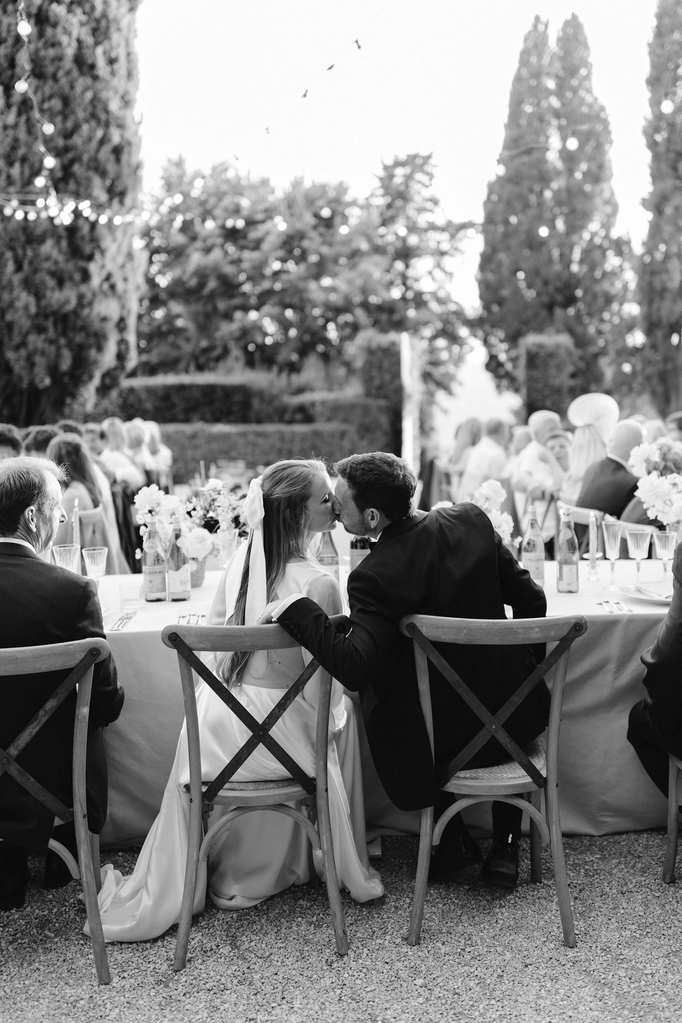 couple kiss during italian wedding dinner in tuscan