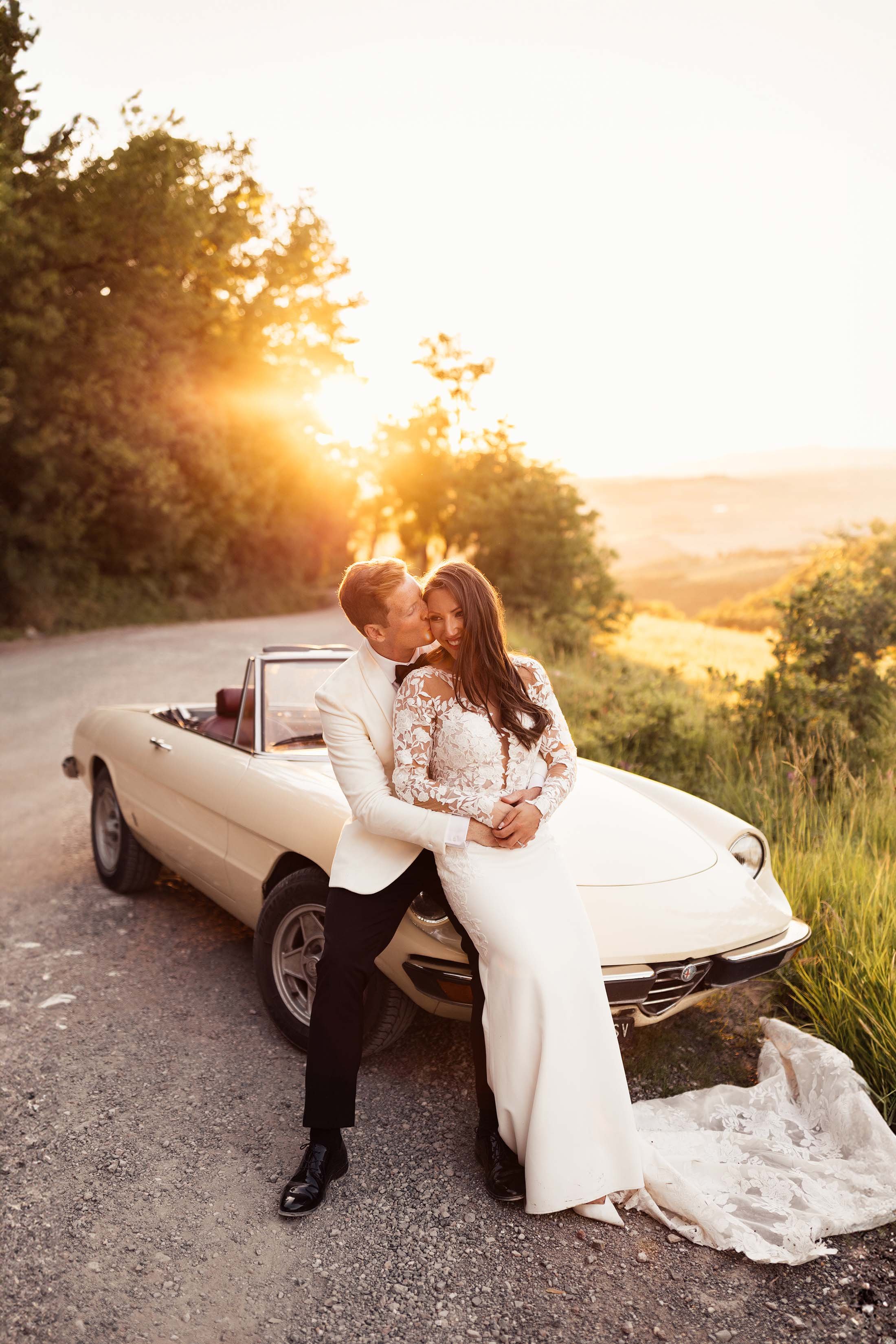 sunset wedding photos with white alfa Romeo