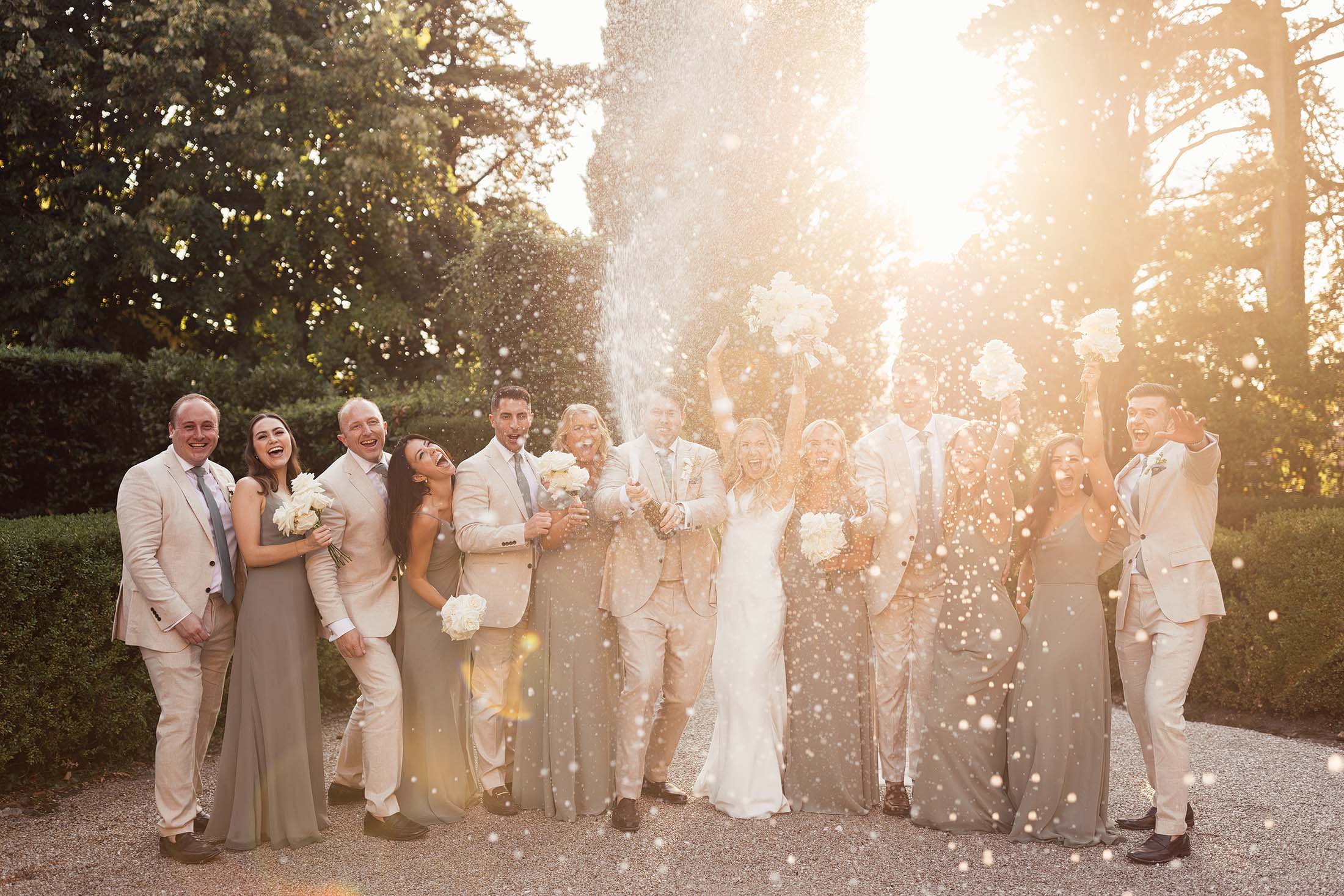 bride sprays champagne with bridal party
