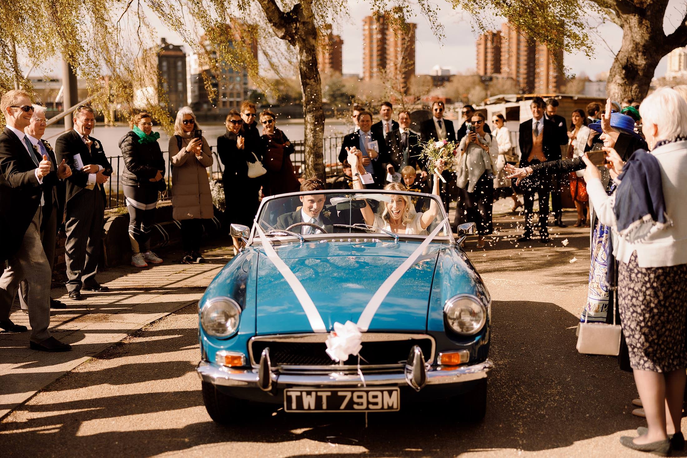 bride and groom confetti exit in vintage blue MG car