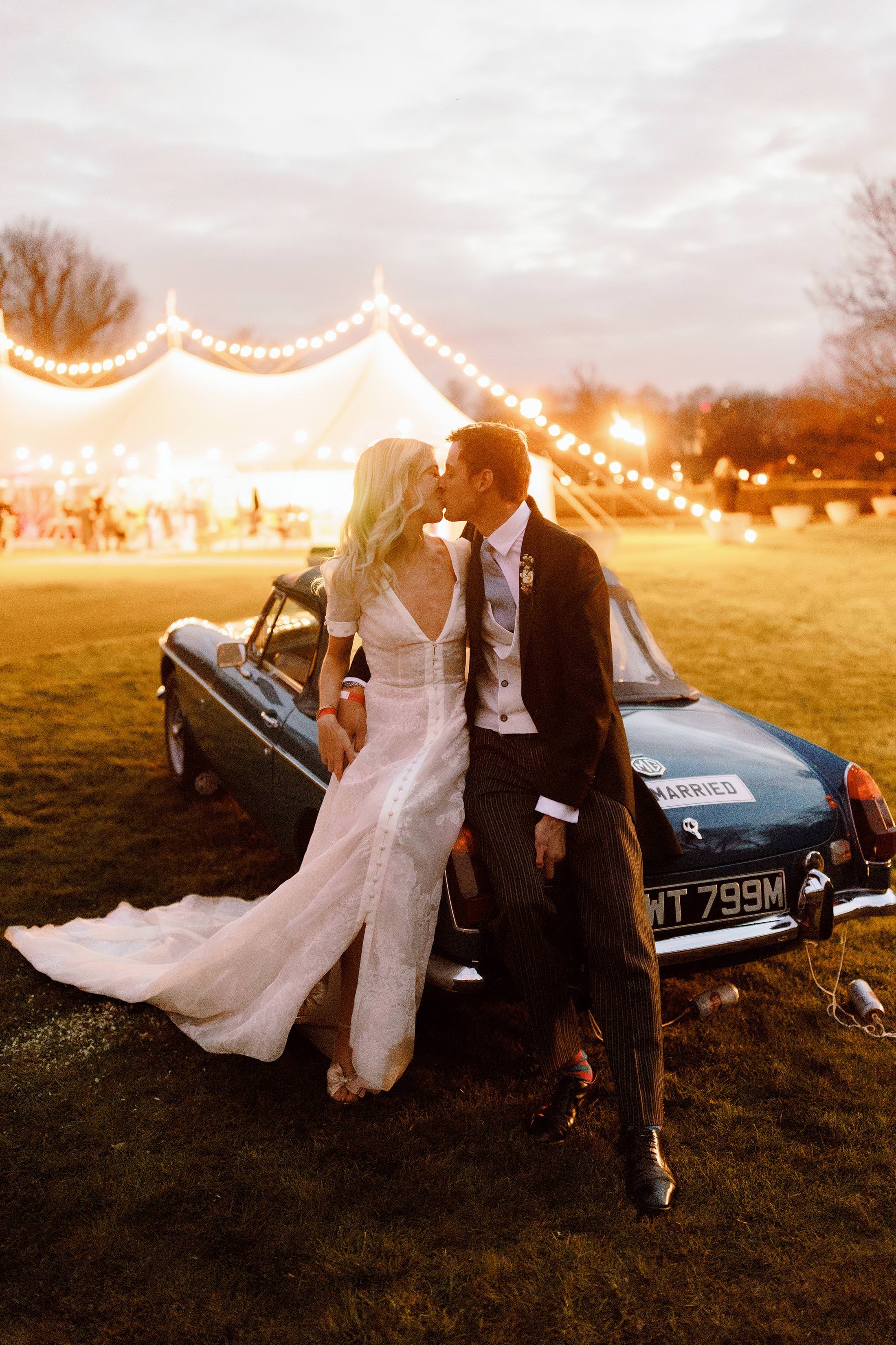 bride and groom pose for photo on vintage blue car at london wedding