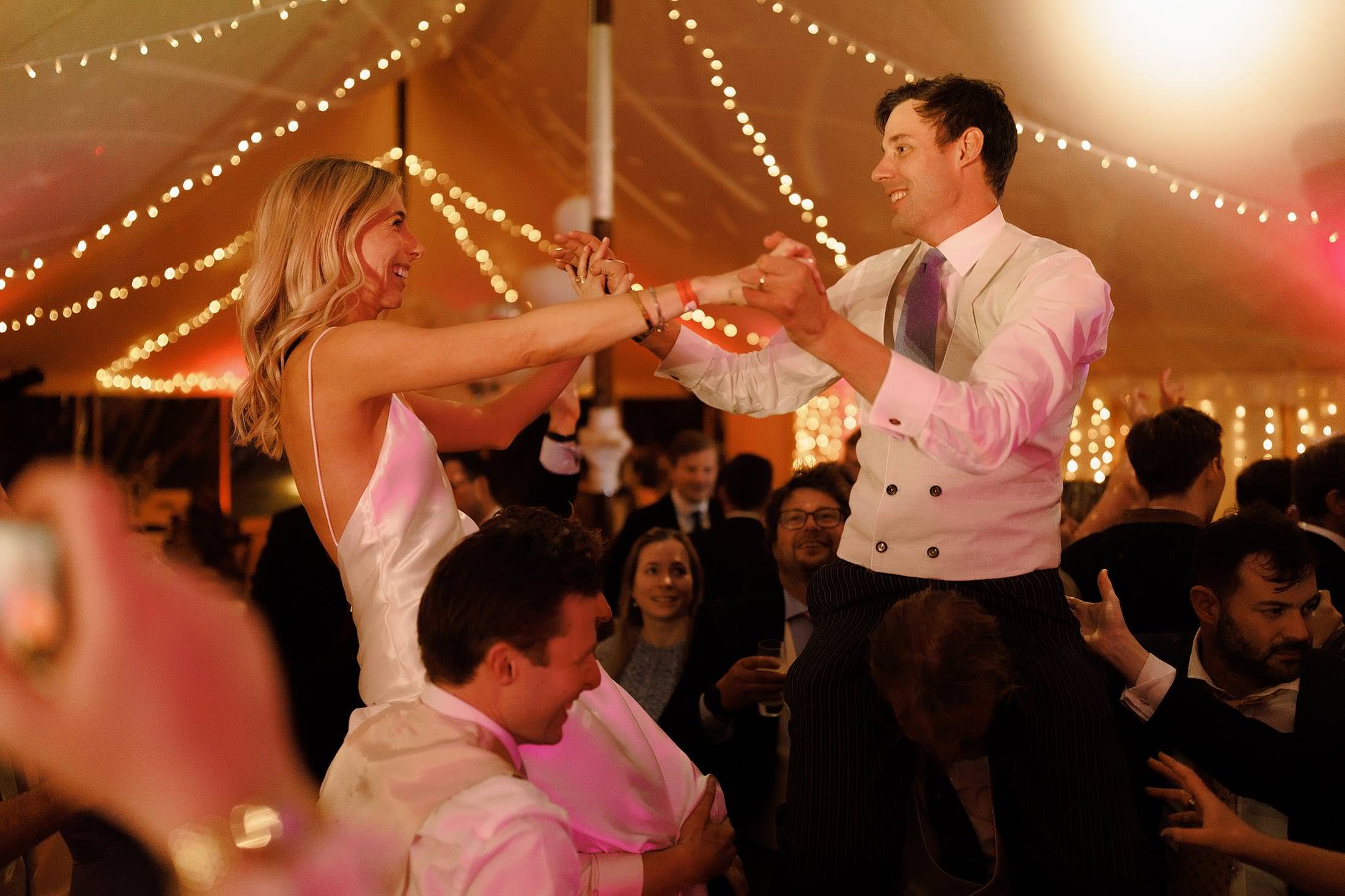 bride and groom dance on guests shoulders at london wedding