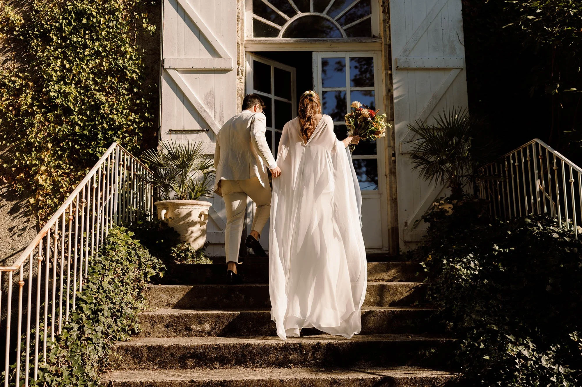 bride and groom go inside chateau de lartigolle france wedding venue