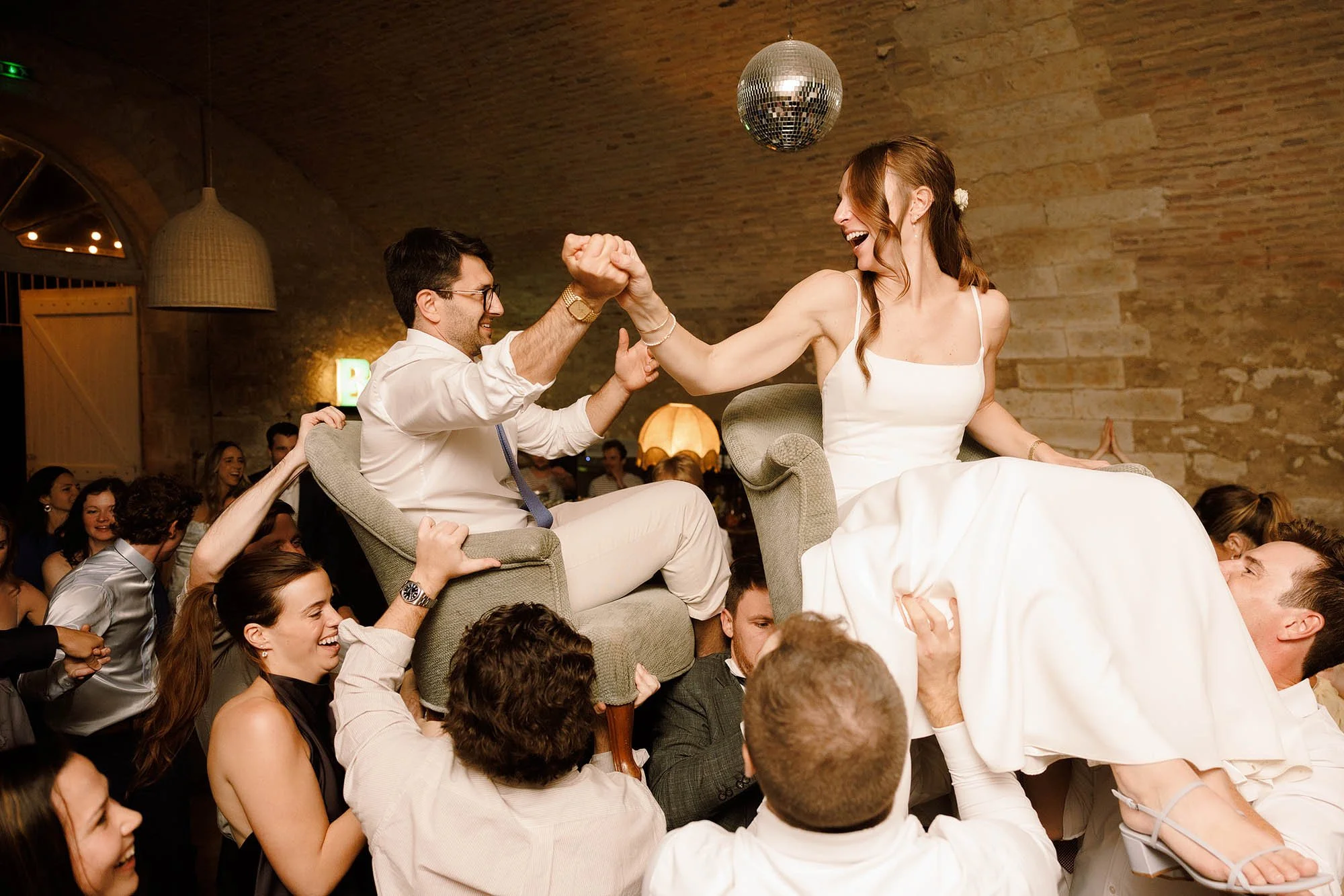 bride and groom lifted up on chairs during dancefloor at south of france wedding