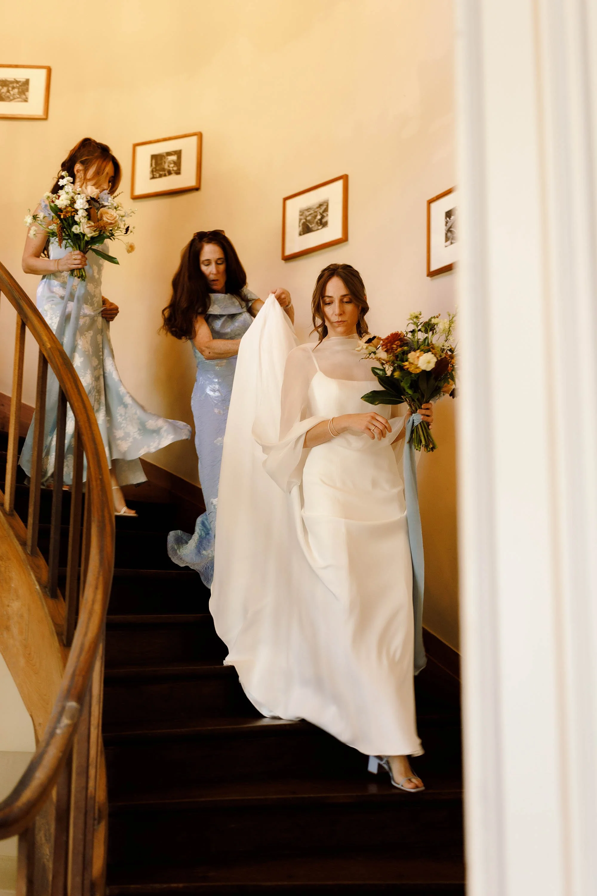 bride in jenny yoo dress walks down stairs at chateau wedding venue