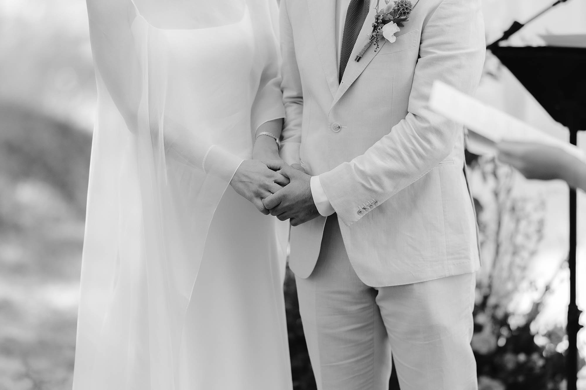 bride and groom hold hands during wedding ceremony in the south of france