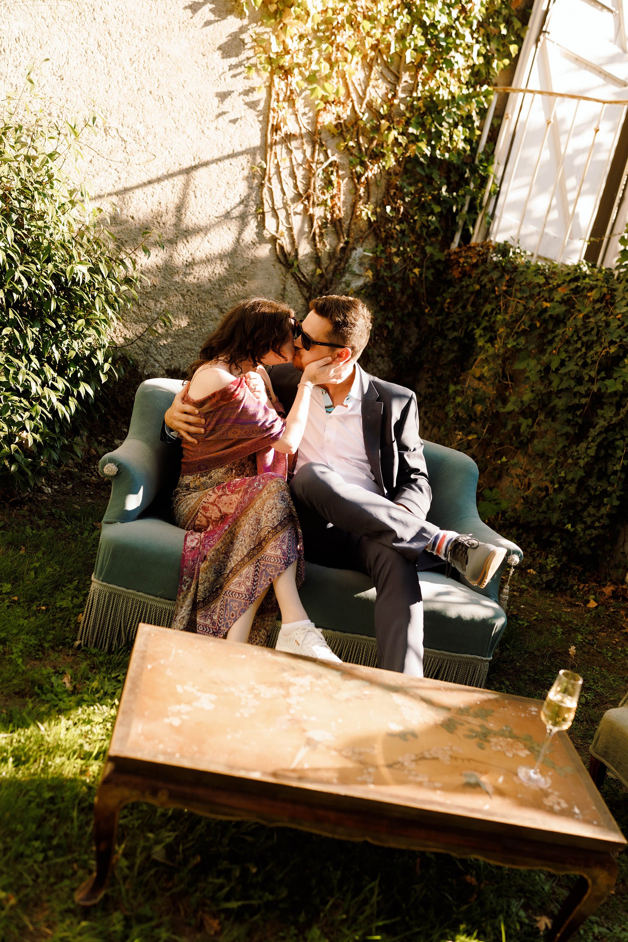 wedding guests share a kiss during drinks reception at chateau de lartigolle france