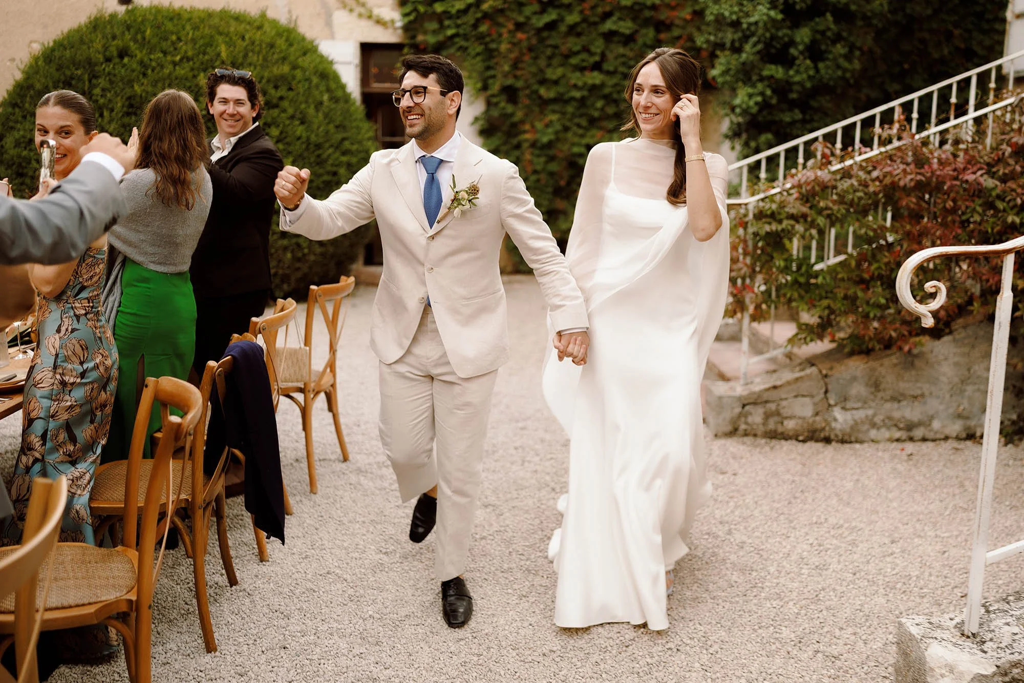 bride and groom enter outdoor wedding dinner at chateau venue