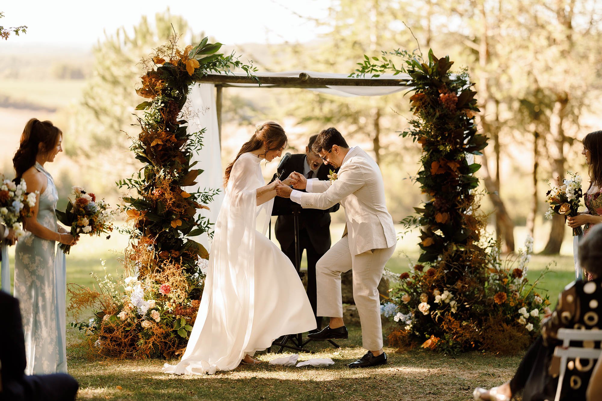 bride and groom step on glass during jewish ceremony at chateau de lartigolle