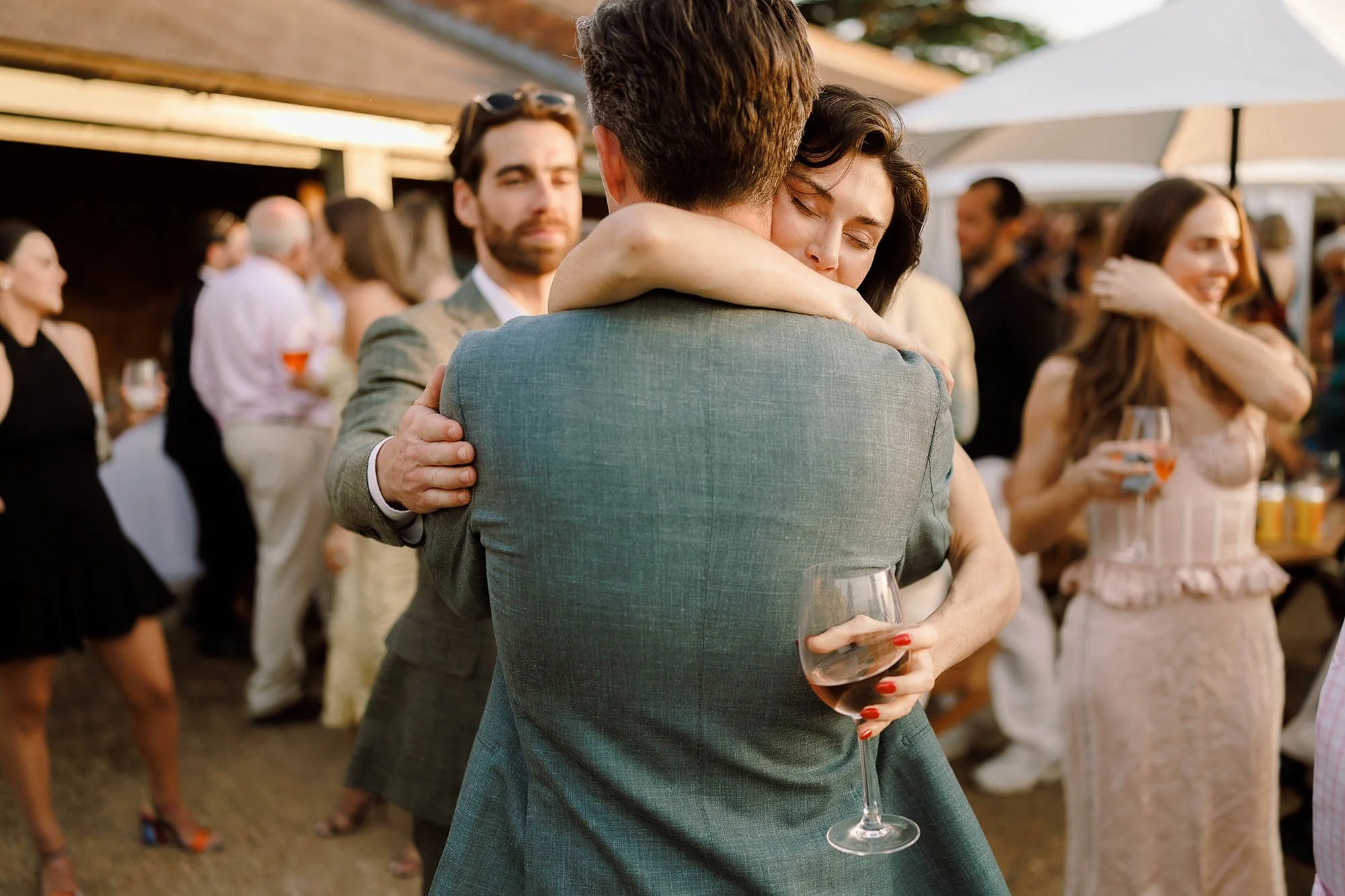 guest hugs groom during night before drinks reception