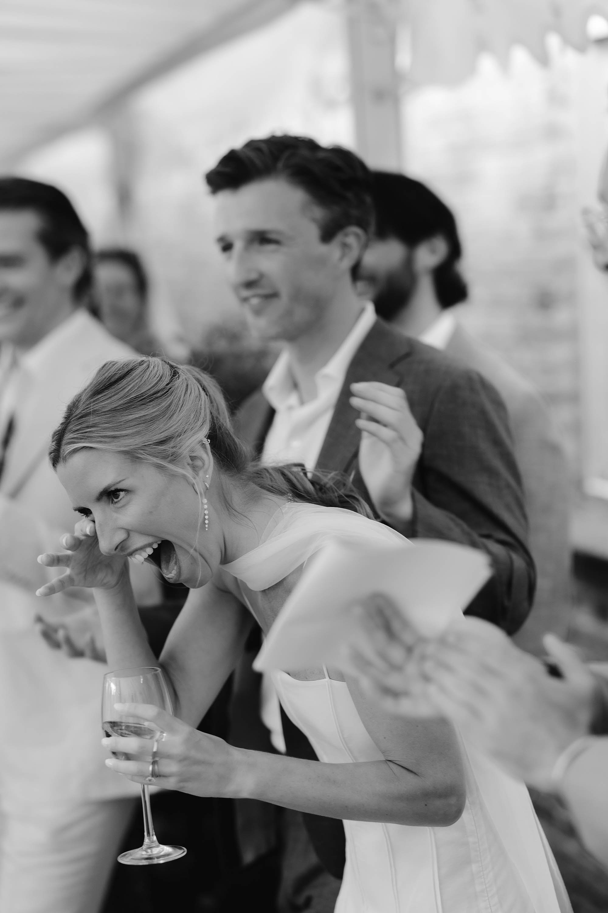 bride laughs during speeches at day before wedding event