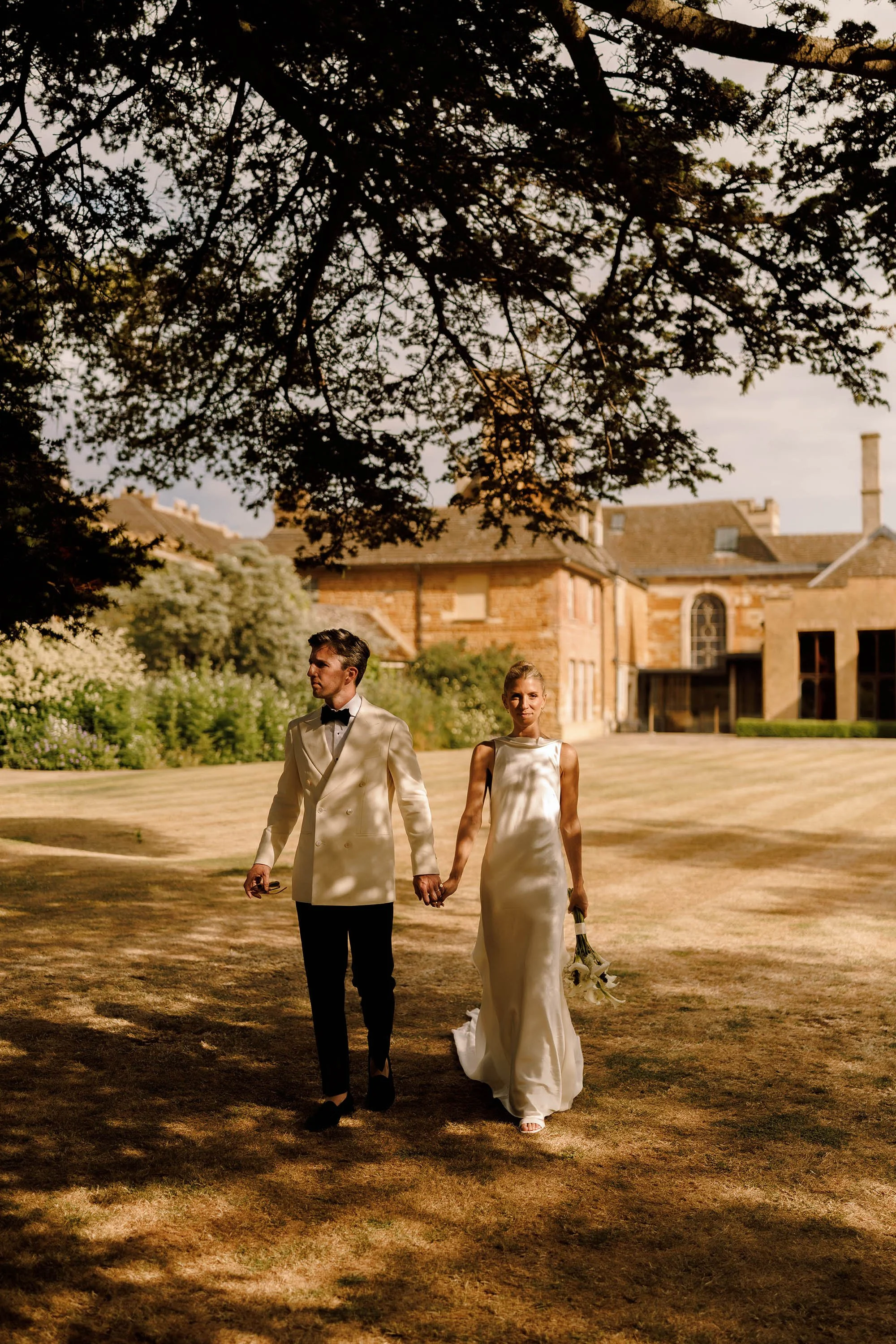 bride in danielle frankel wedding dress and groom in white tuxedo